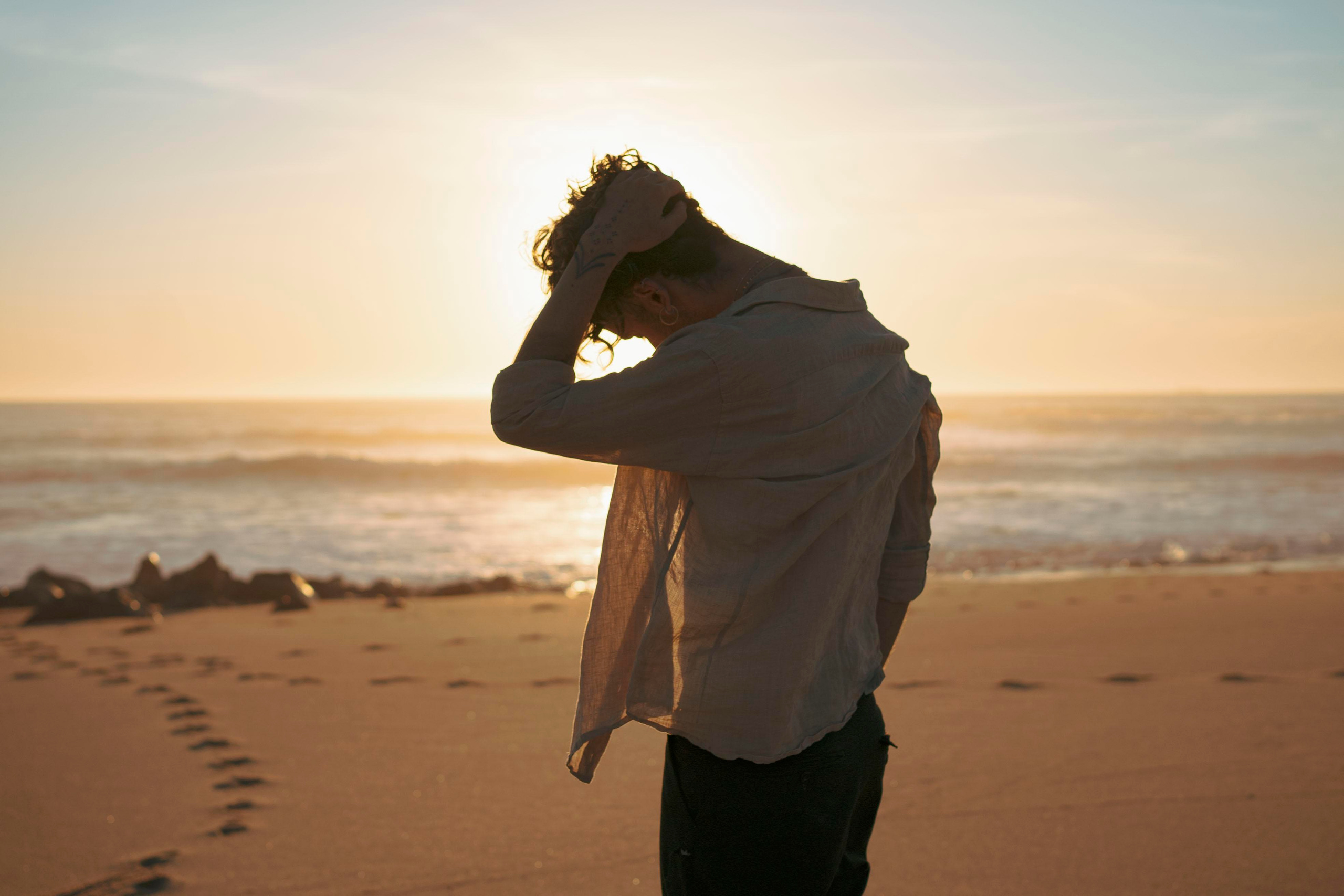 Silhouette of a person with a sunset sky in the background.
