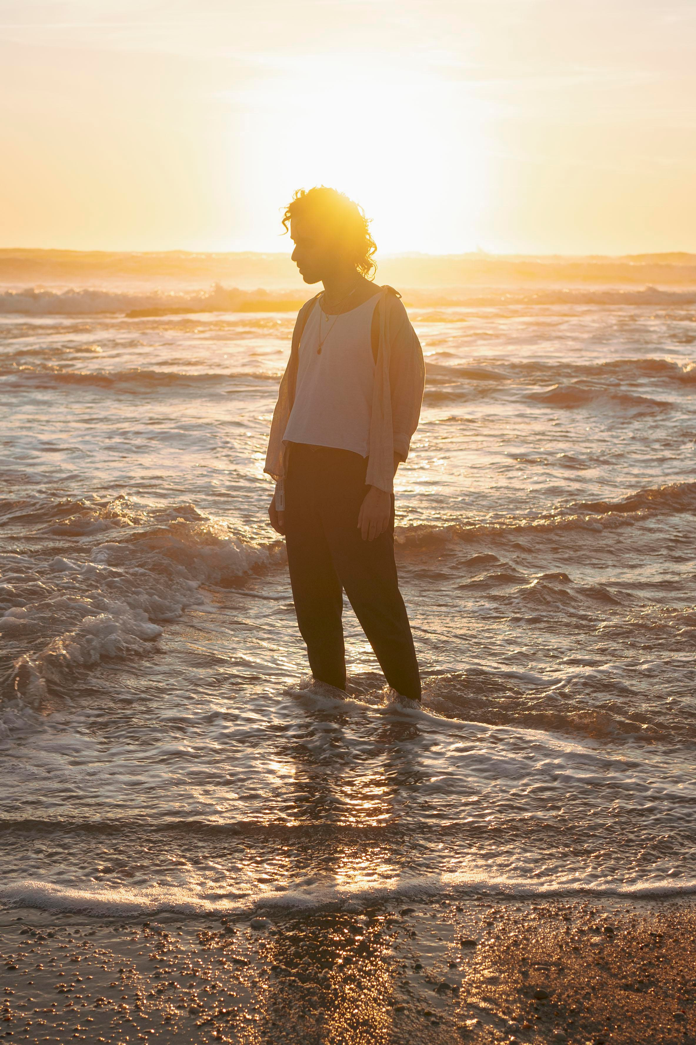 LGBTQ+, LGBT portrait of a beautiful person with makeup, a white tank top, and curly hair.