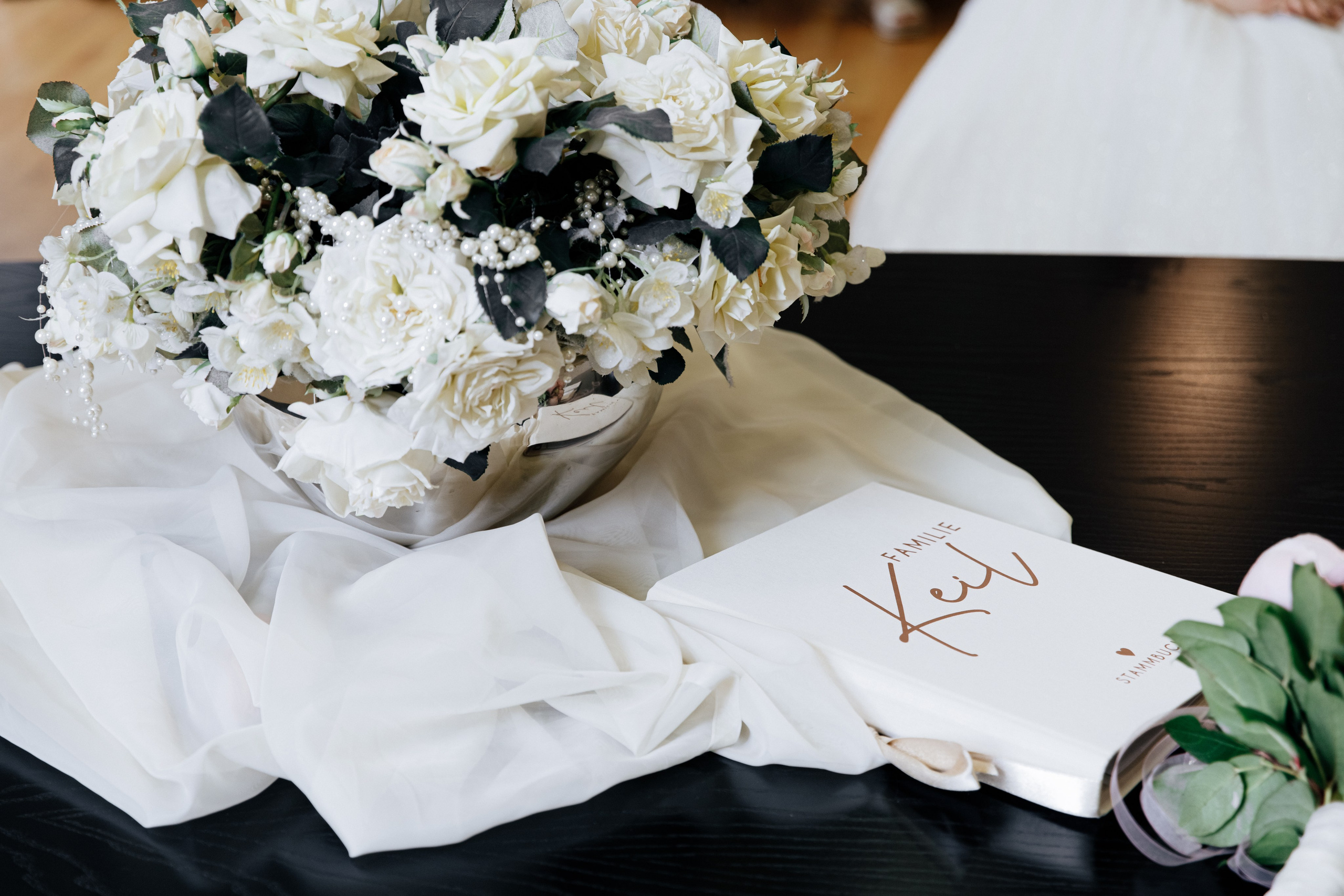 Detailaufnahme des Brautstraußes und des Stammbuchs.