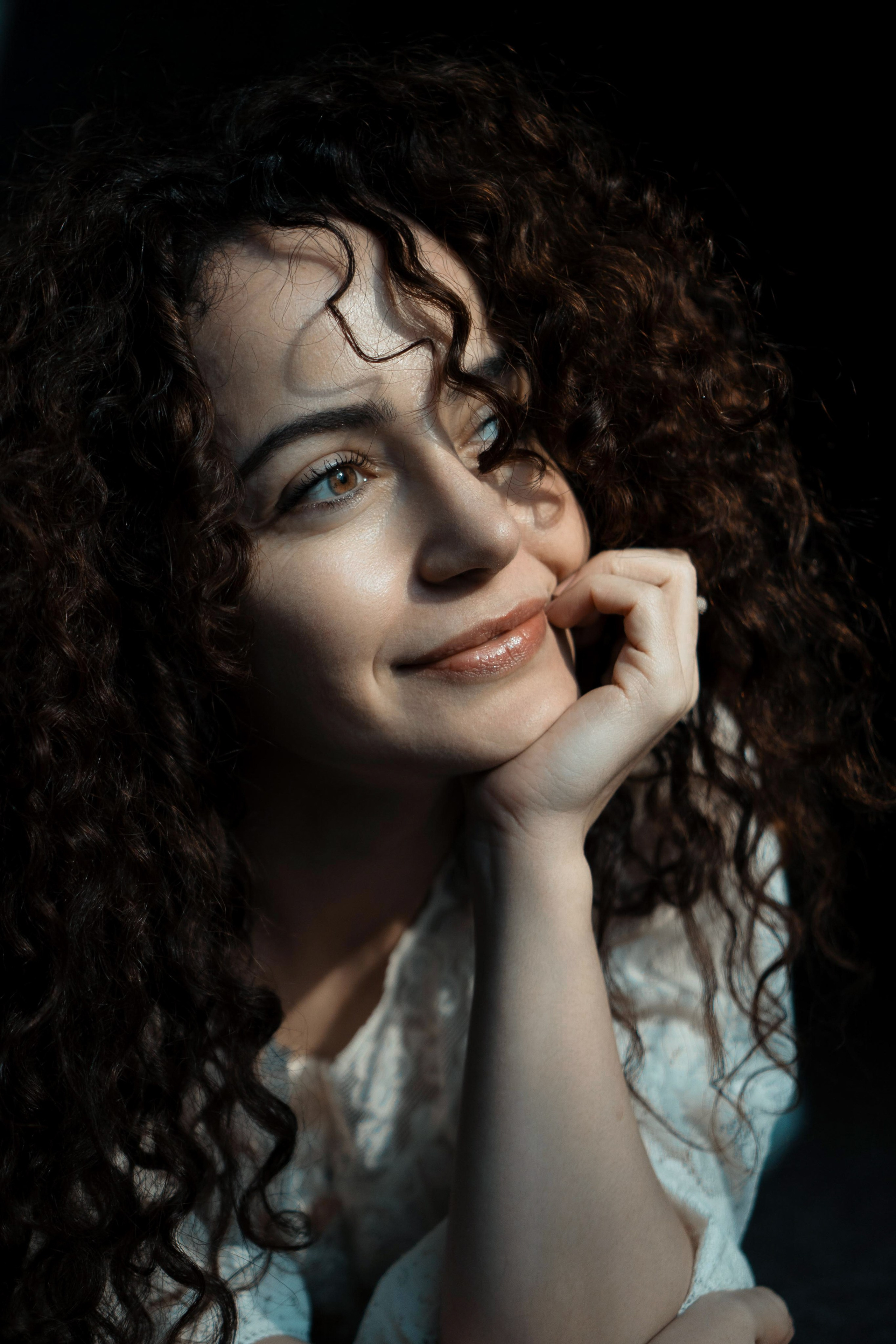 Natürliches Portrait einer Frau mit lockigem Haar, Lächeln im sanften Licht – Portraitfotografie Dresden