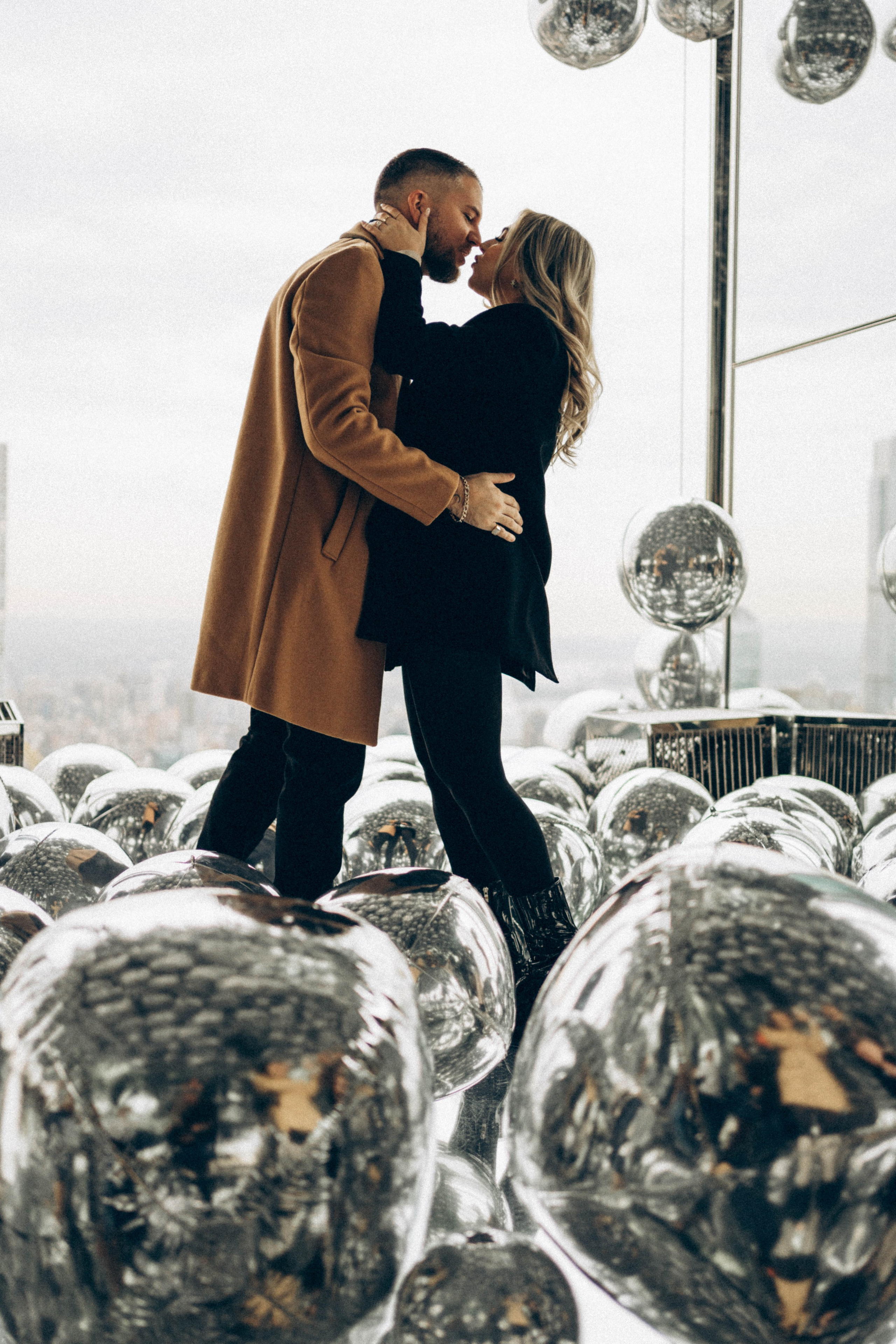 Couple celebrating in front of Brooklyn skyline.