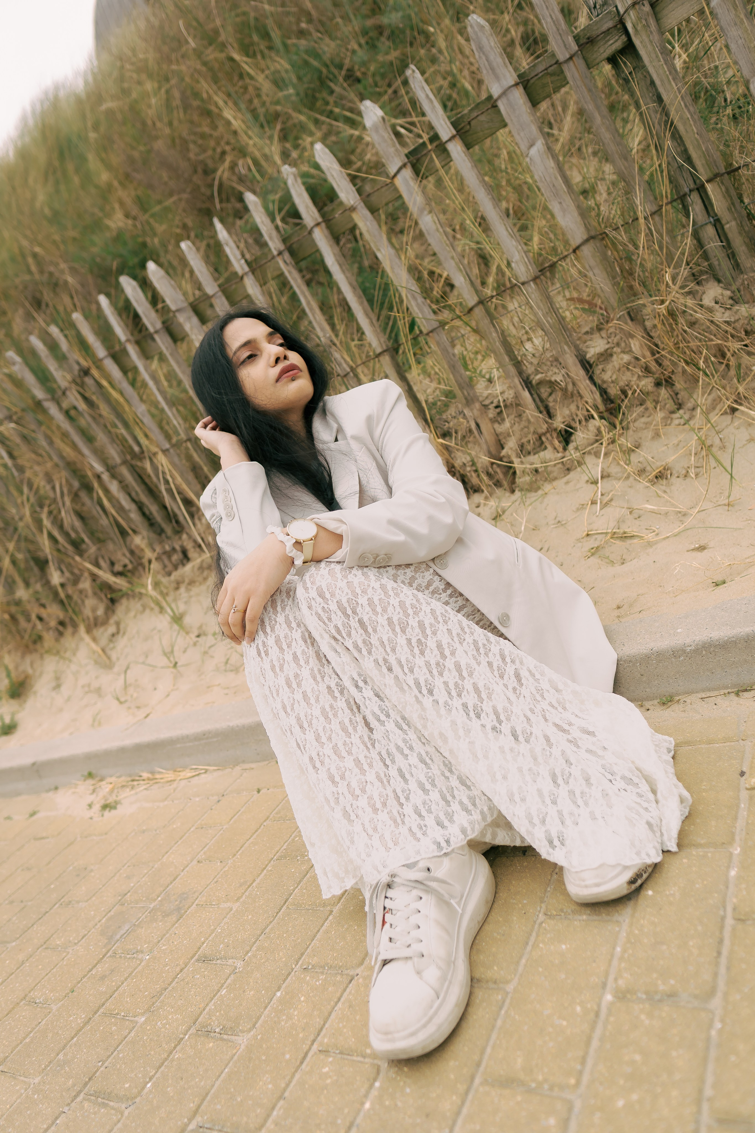 Fashion photoshoot in dunes with lace skirt and white blazer