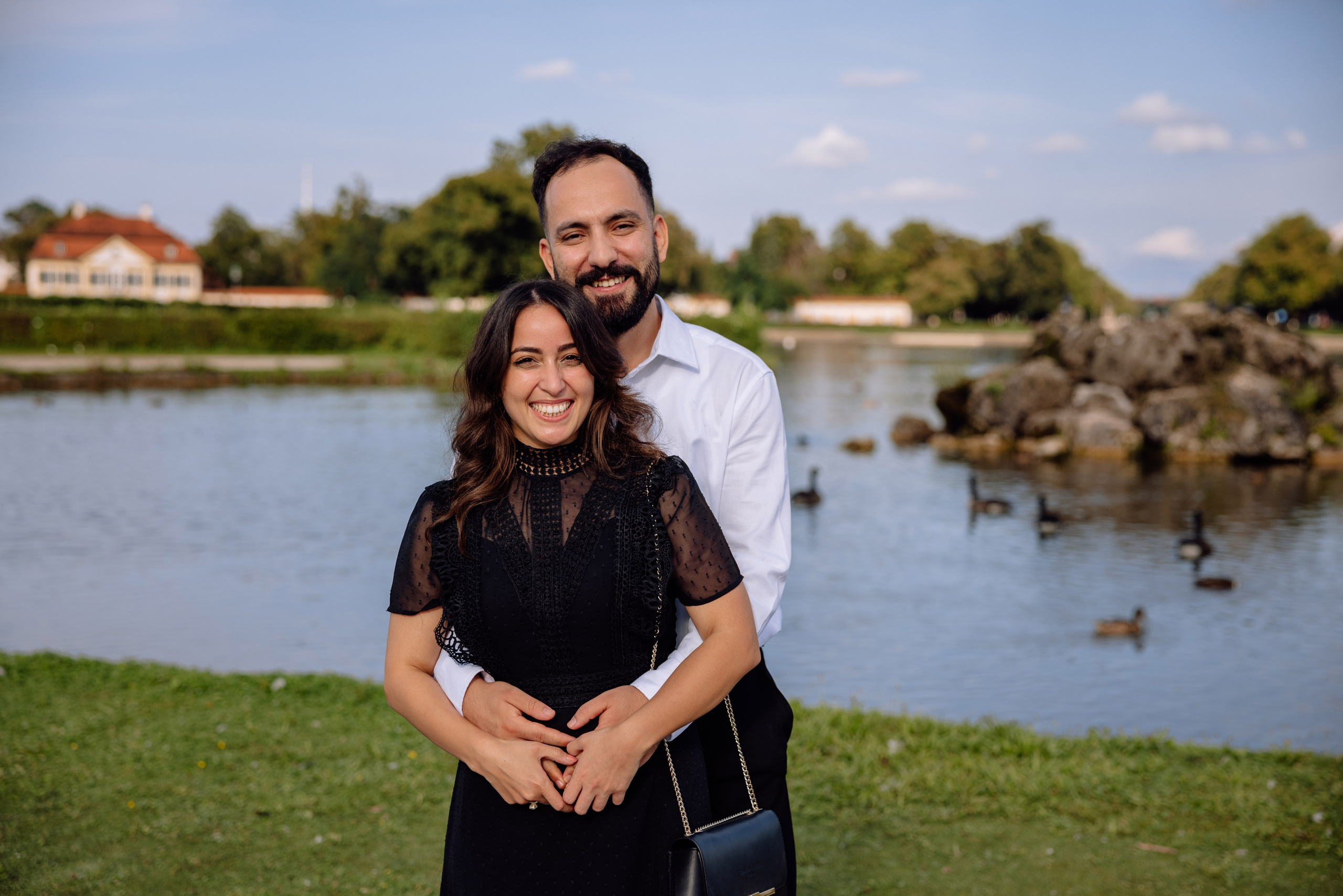 Verlobtes Paar umarmt sich vor dem Schloss Nymphenburg