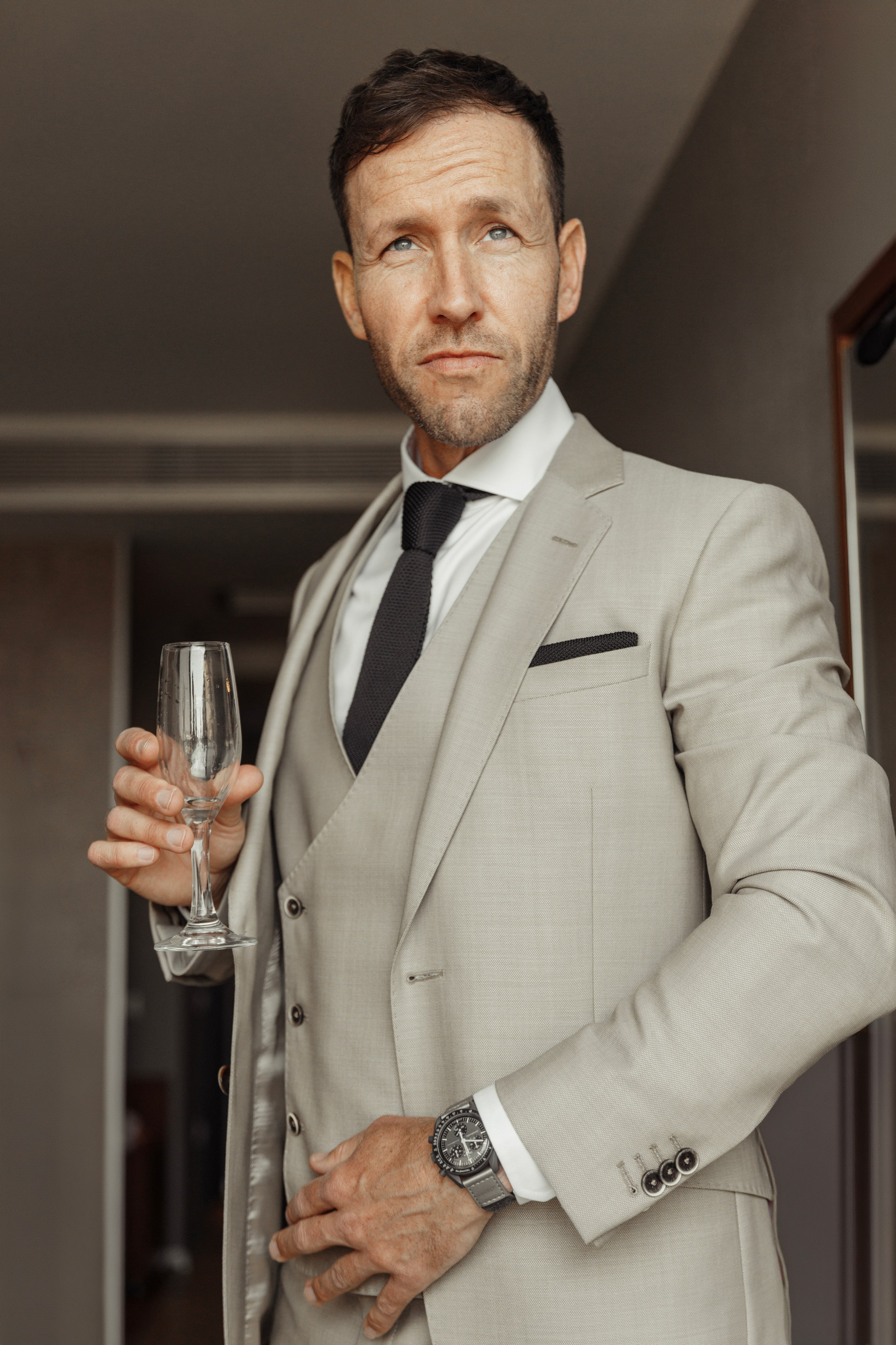 the groom with a glass of champagne looks haughtily at his friend. Rhodes, Greece