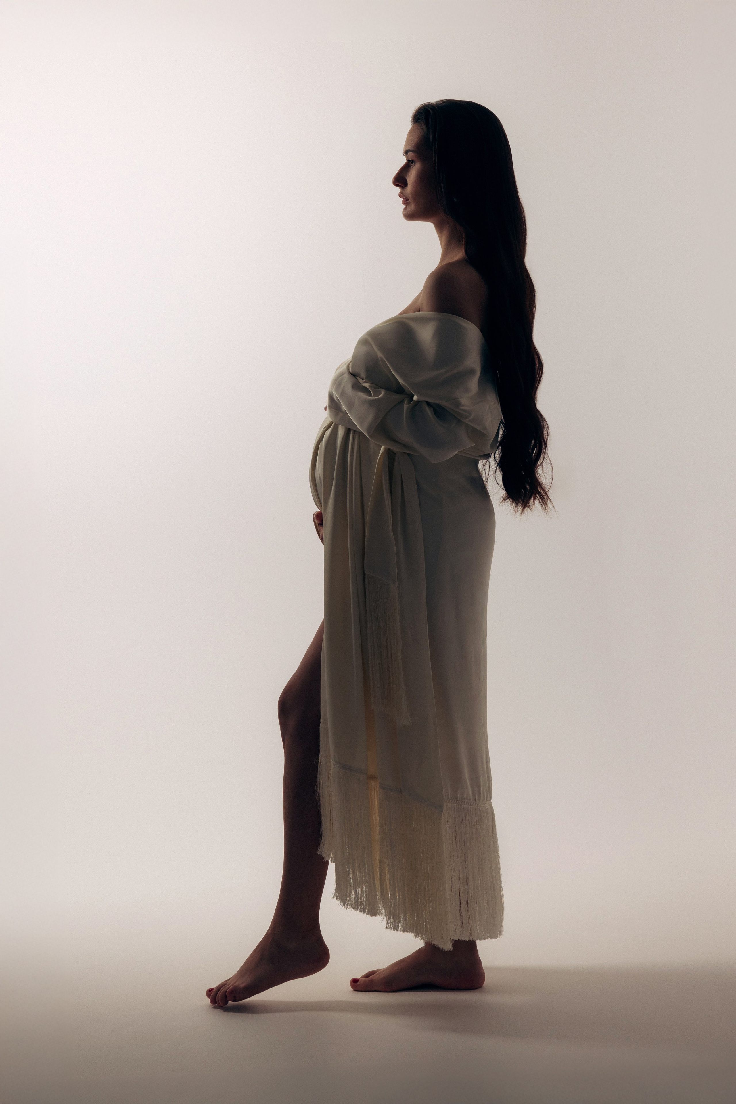  Artystyczna sesja ciążowa – kobieta z rozłożonymi ramionami w ruchu, swoboda i kobieca siła.  Artistic maternity session – woman with arms open in motion, freedom and feminine power.