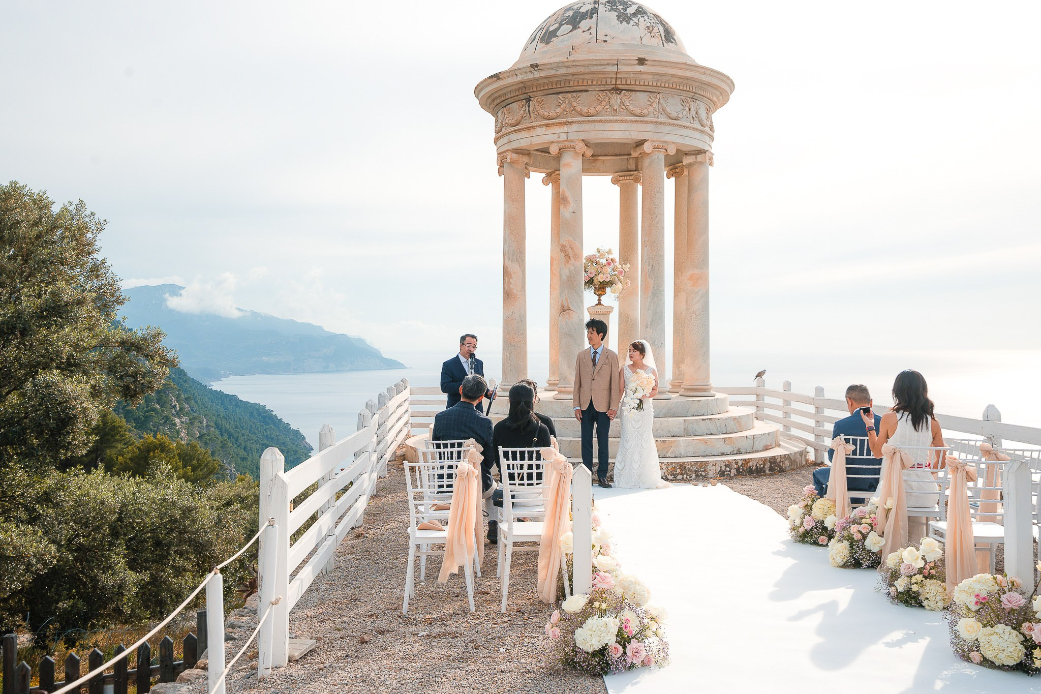 Wide view of the Son Marroig wedding ceremony with bride, groom, and guests overlooking the coastline