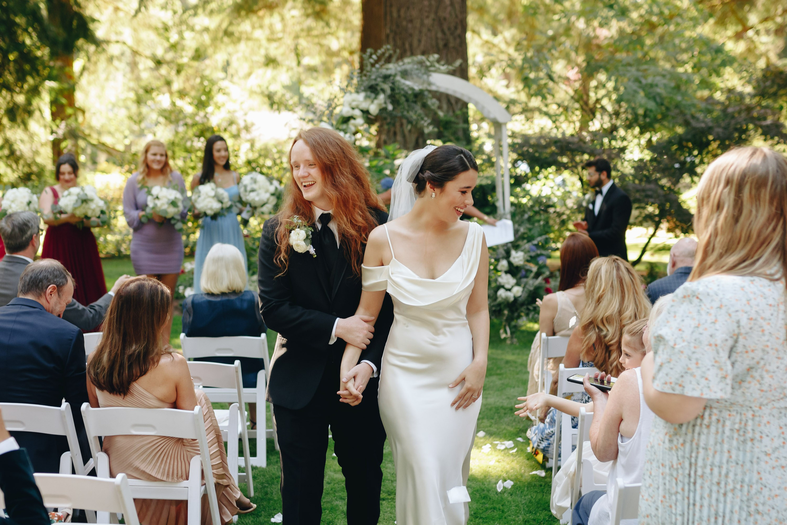 Outdoor wedding ceremony with guests, joyful atmosphere