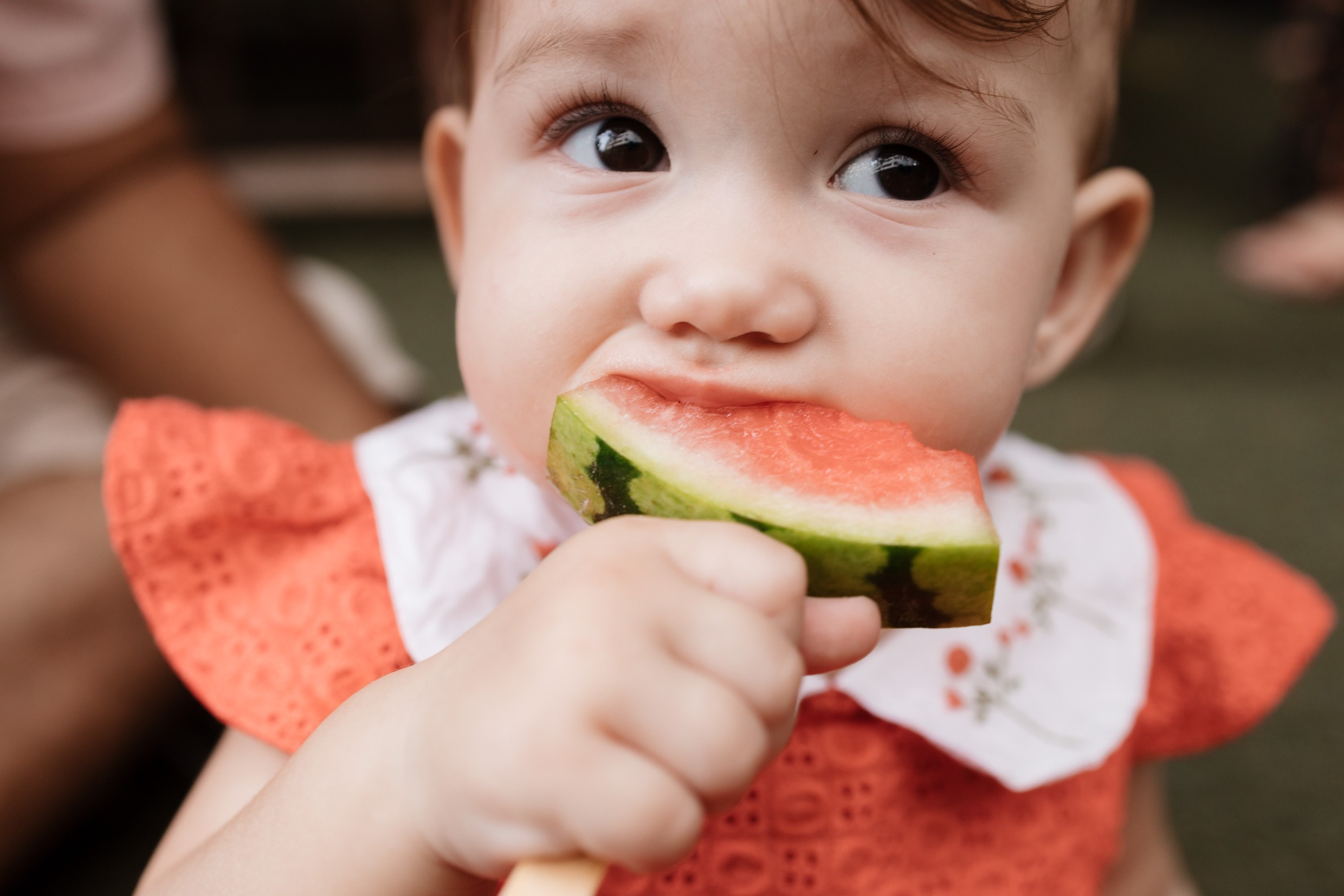 Criança comendo melancia na festa de aniversário