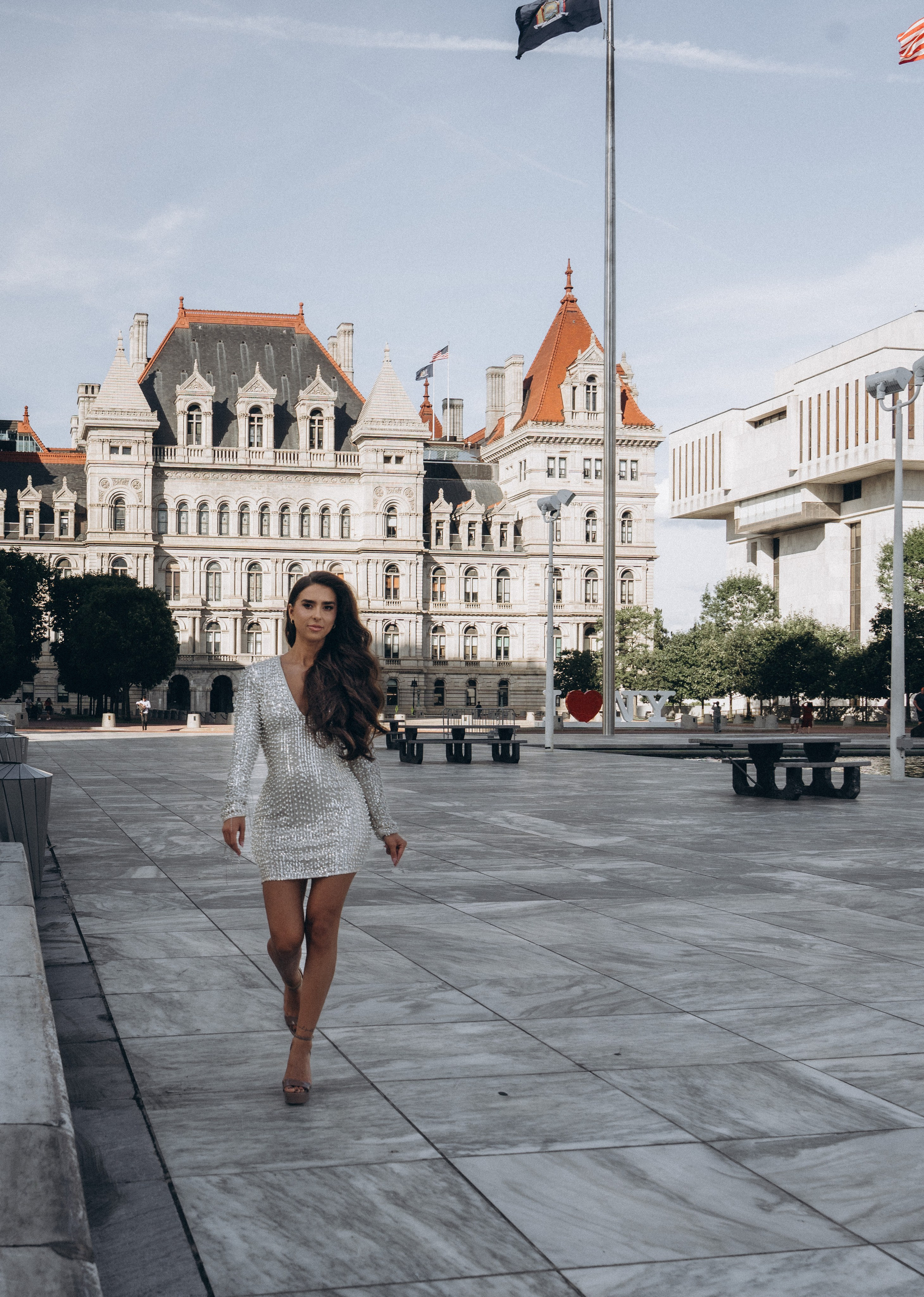 Bride leaning on fence in Hudson Valley field.