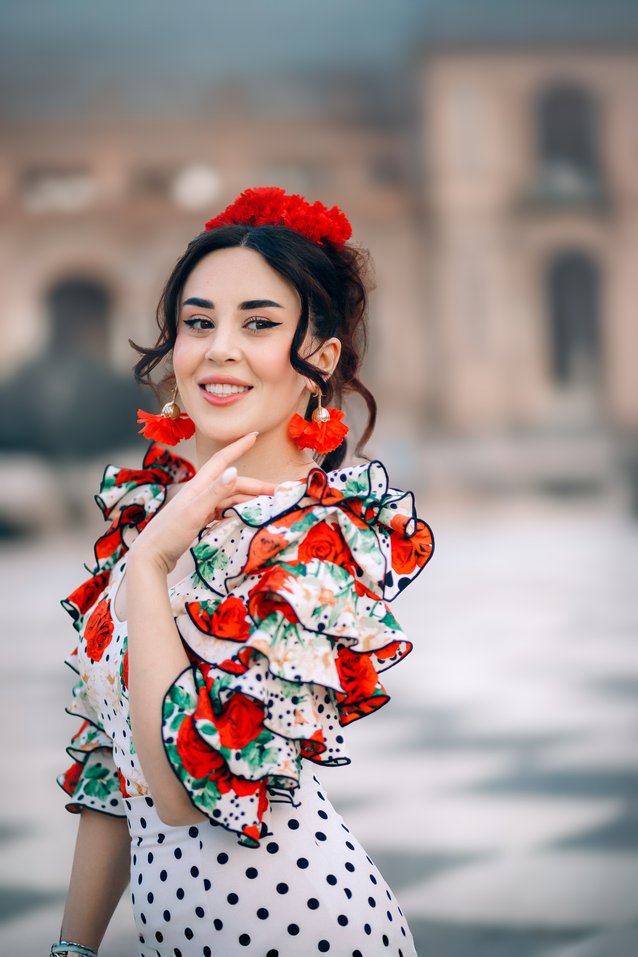 Яркий портрет женщины в традиционном платье фламенко с красными цветами и горошком на площади Испании в Севилье, Испания — идеально для клиентов, ищущих культурные и красочные портретные съёмки в Севилье и южной Испании.