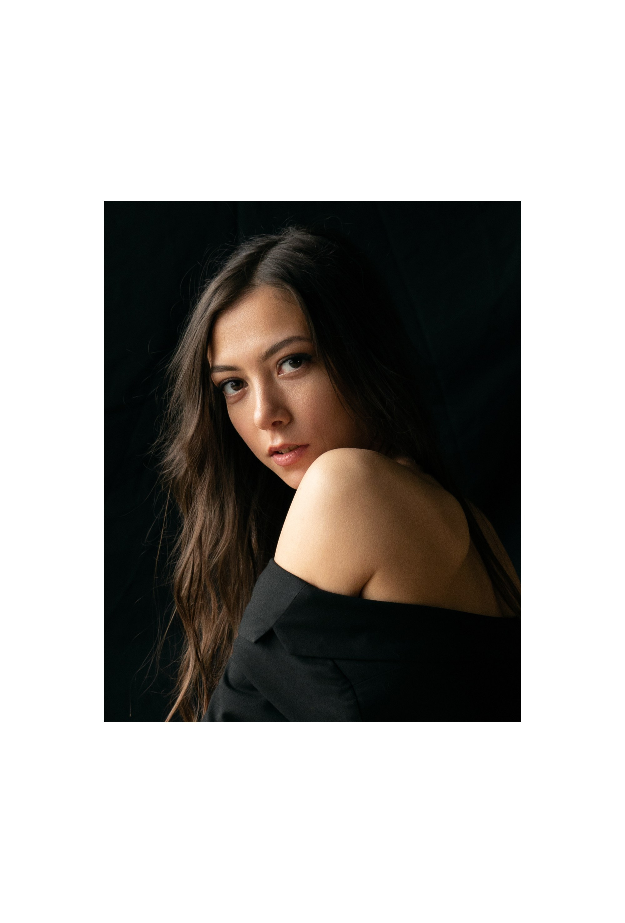 Frau im schwarzen Jackett dreht Kopf zur Kamera