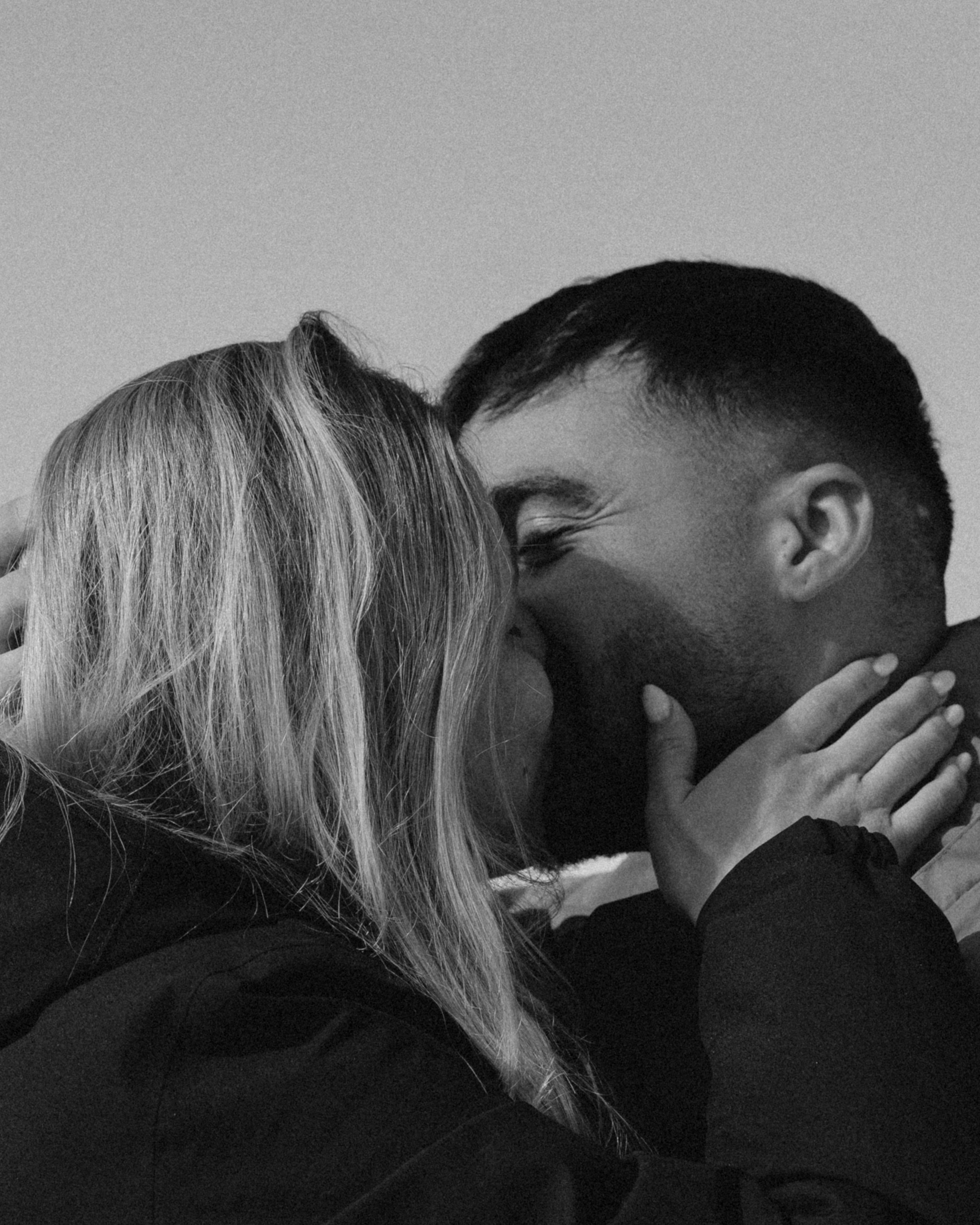 Couple kissing after surprise snowboard proposal at Gudauri ski resort