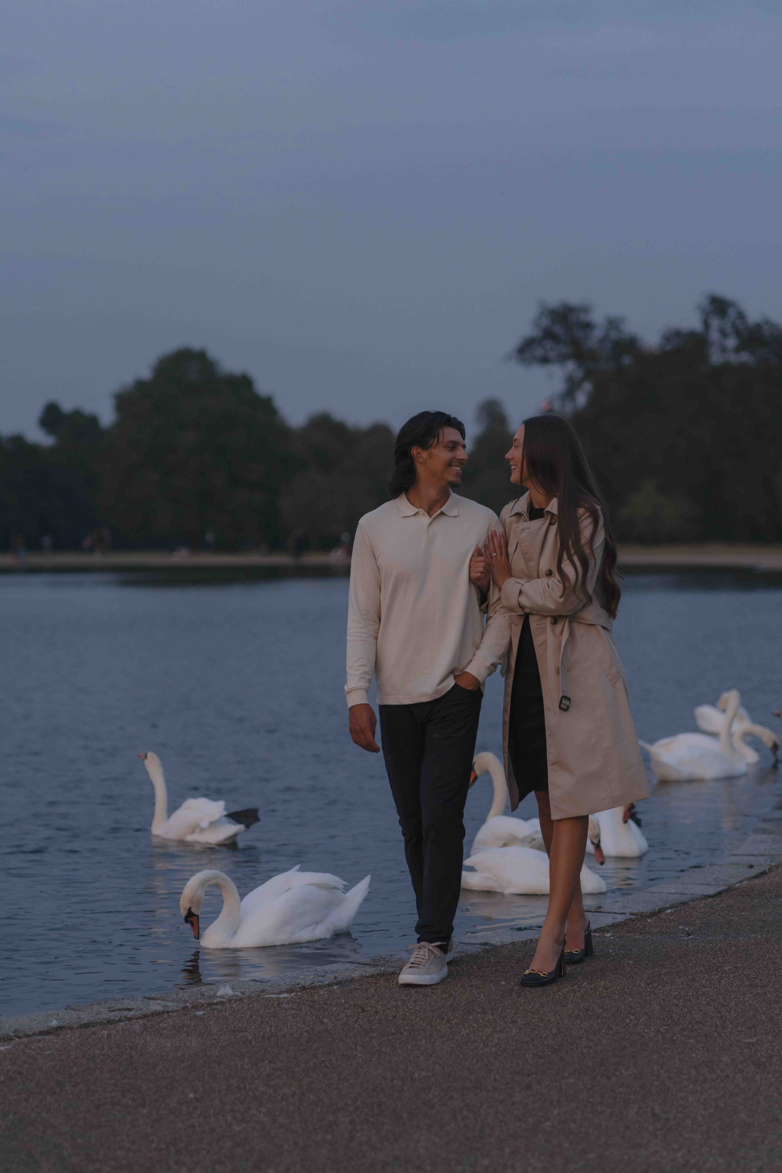 Couple walking in Kensington Gardens after proposal London sunset engagement