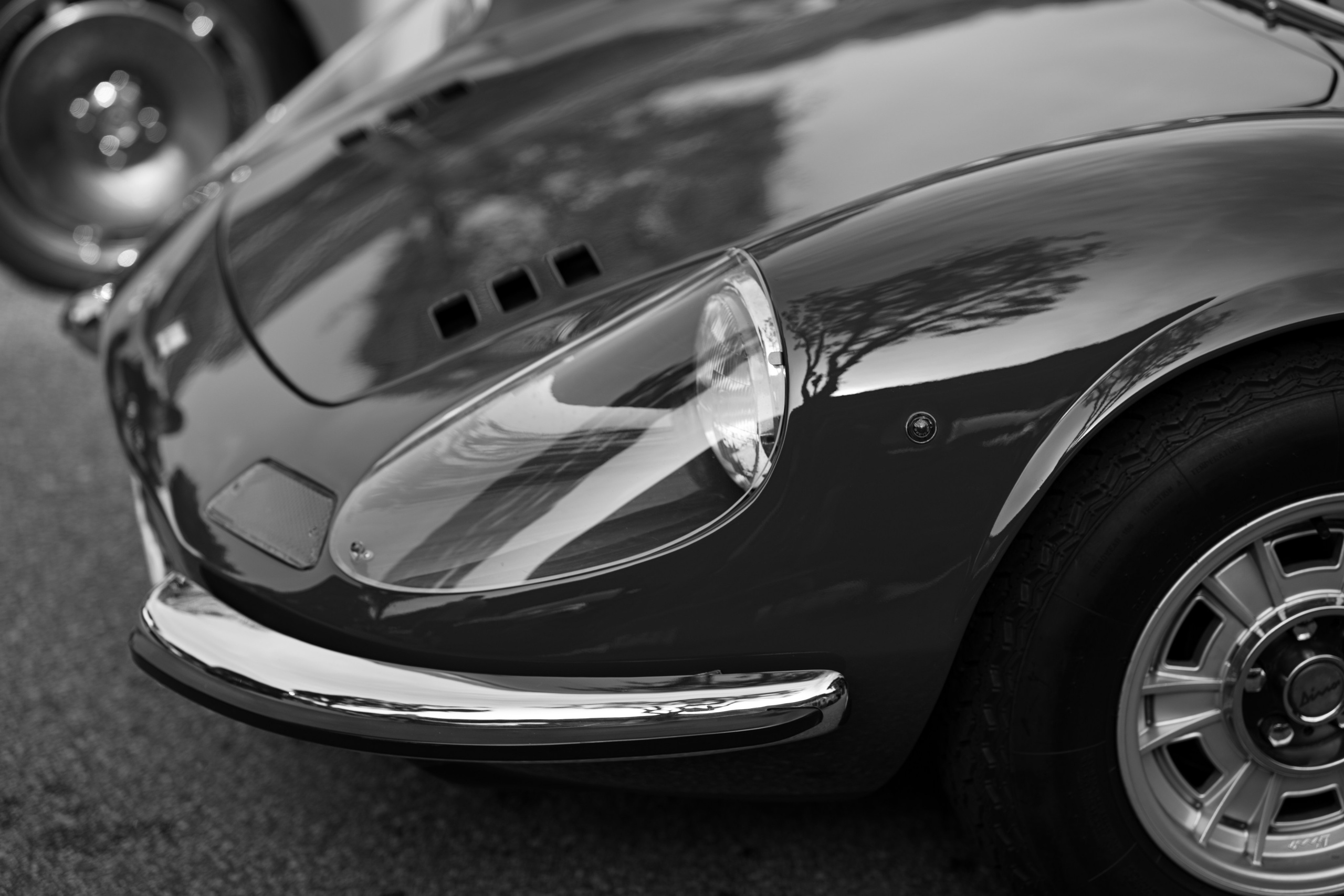 Ferrari Dino headlight close-up – crisp black-and-white detail shot of a classic Ferrari Dino front fender and headlamp, captured by a Singapore automotive photographer for high-end editorial and commercial clients.