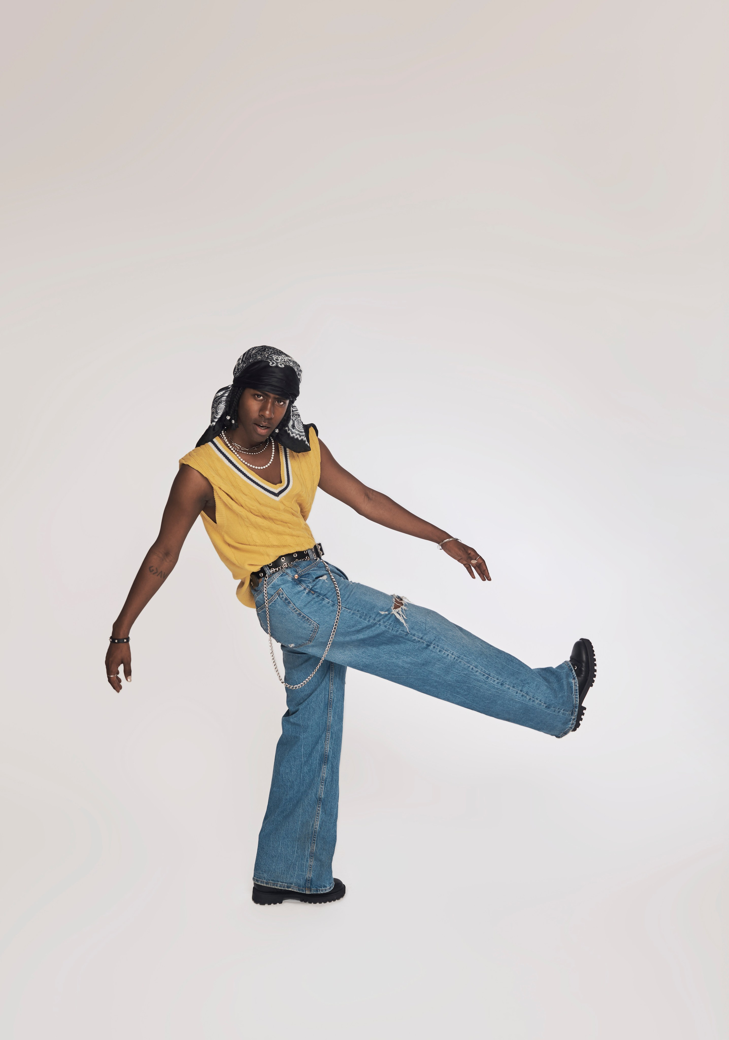 Singer posing seated with one leg up — LA studio photography