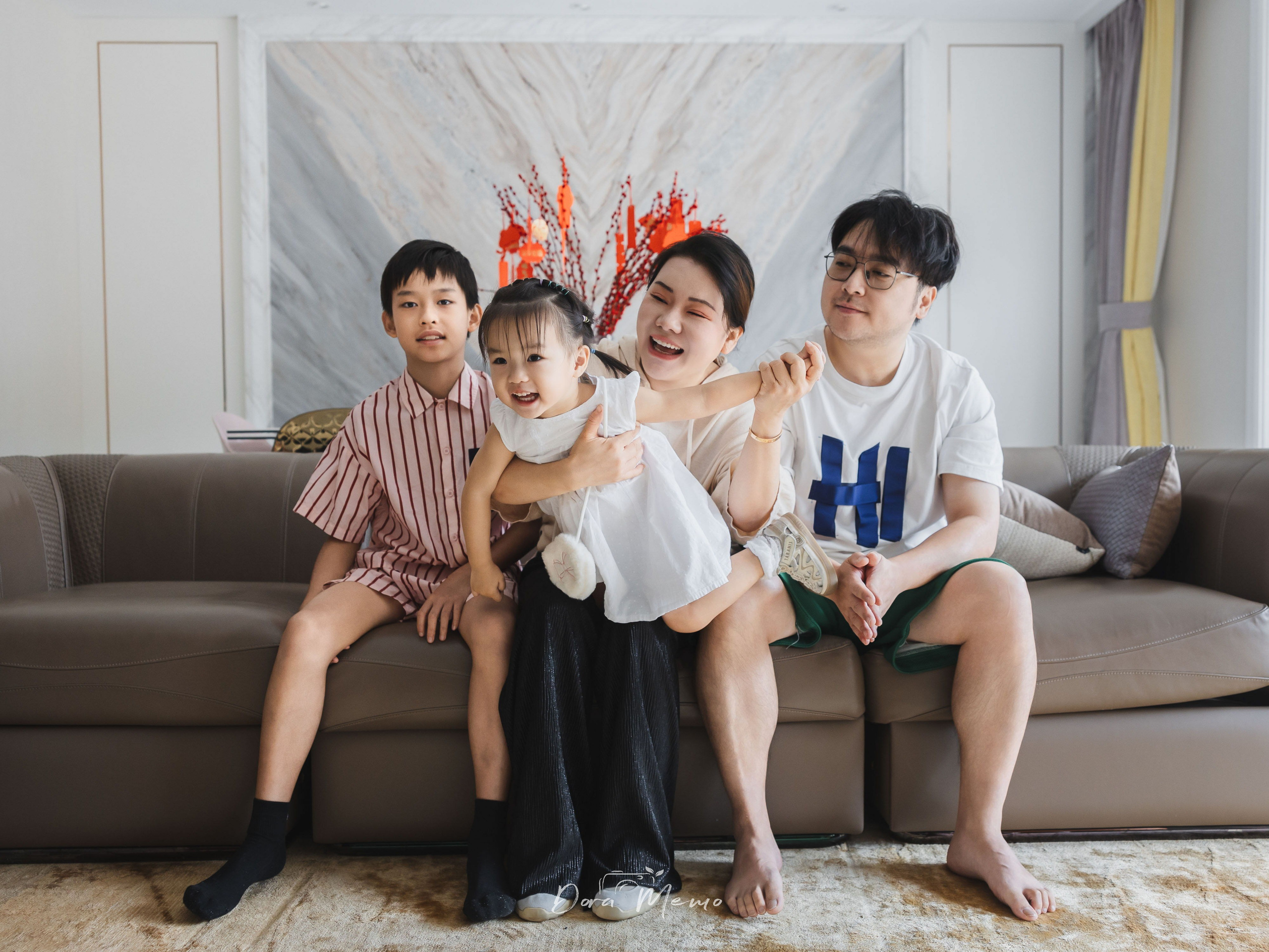 A family of four sits together on the sofa for a final portrait in the home they lived in for eight years.