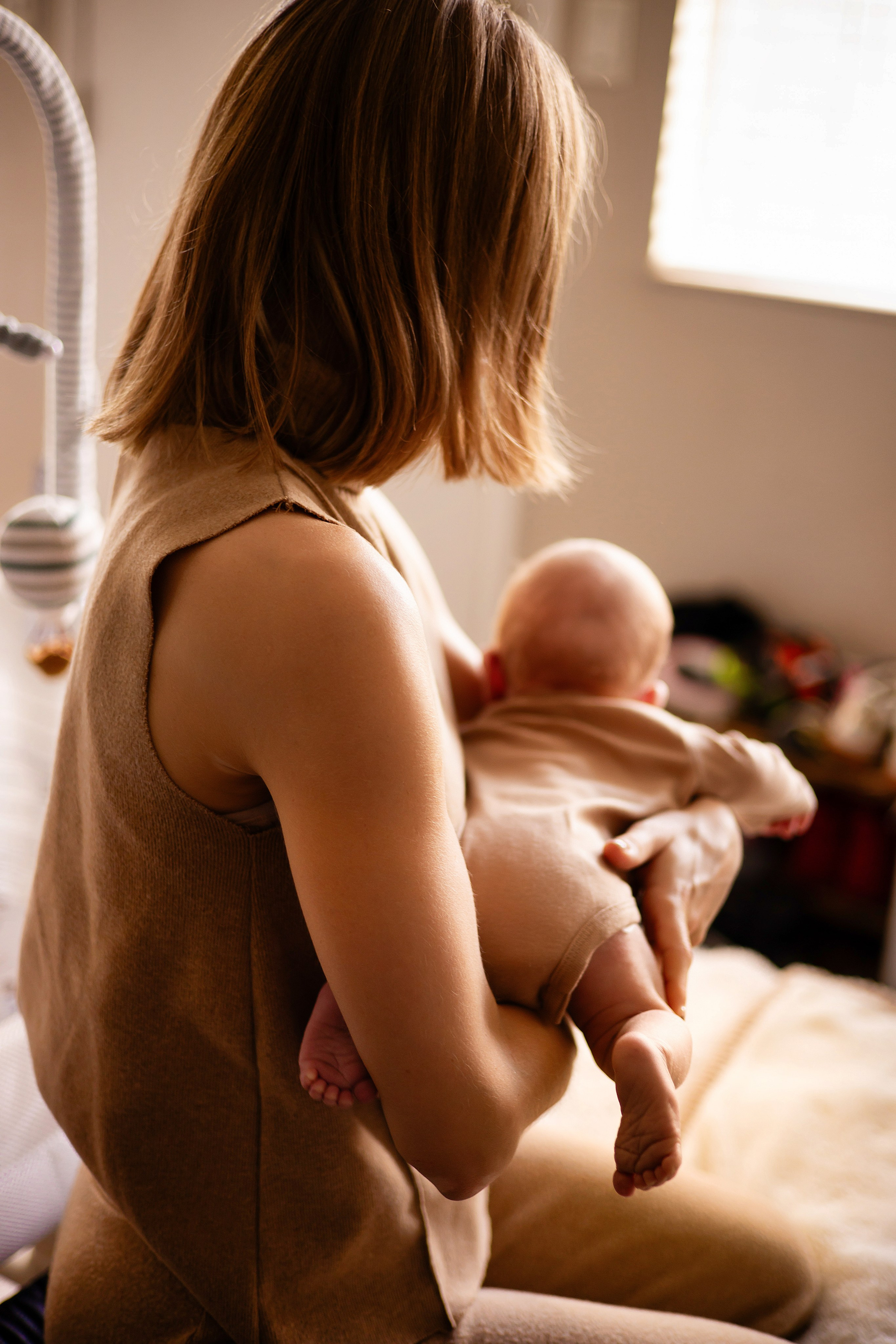 Mother holding newborn by the window