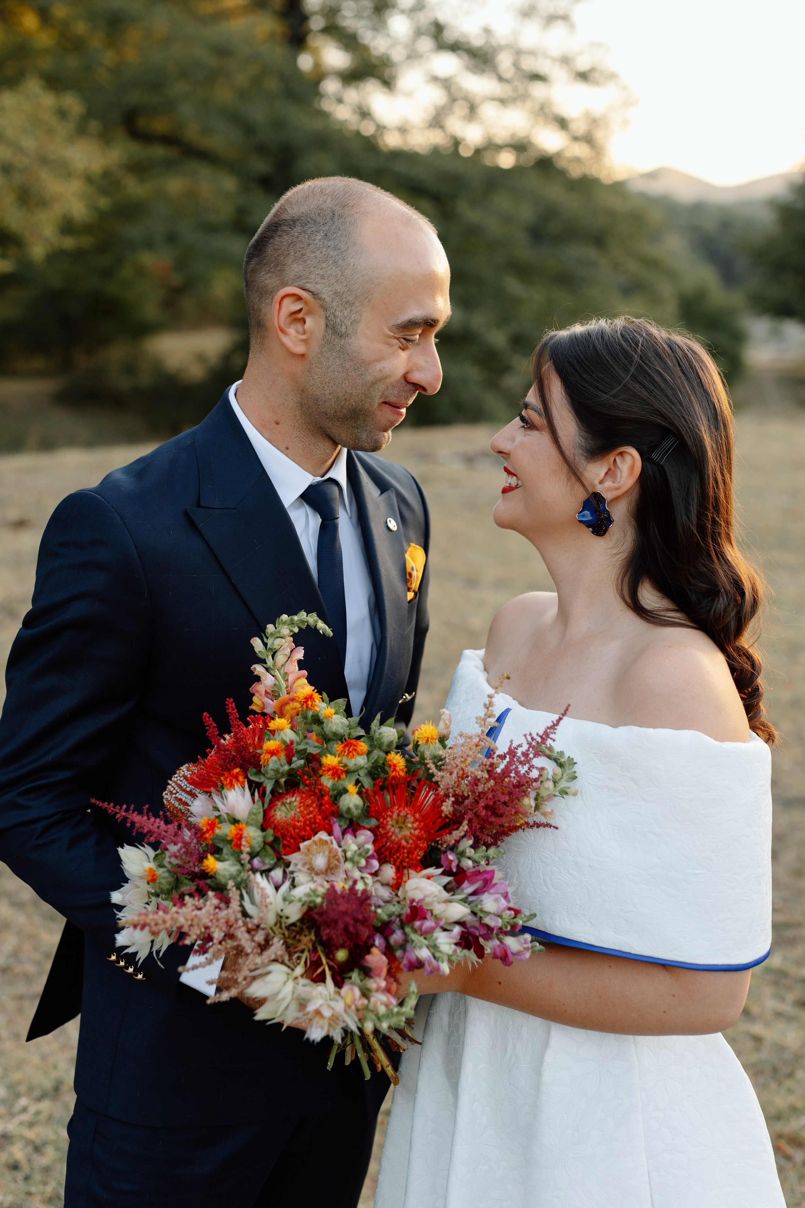 A couple looking at each other on their wedding day at golden hour.