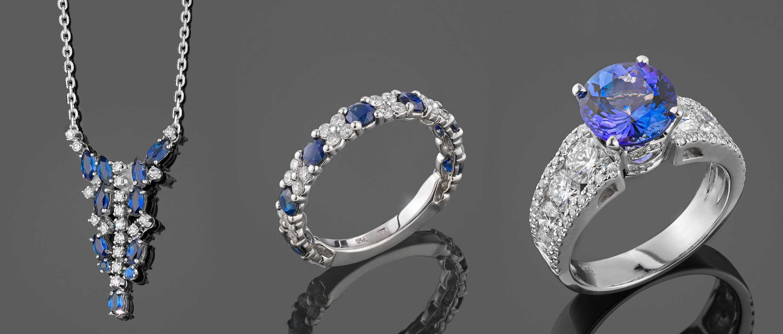 Tri komada zlatnog nakita sa plavim dragim kamenjem.