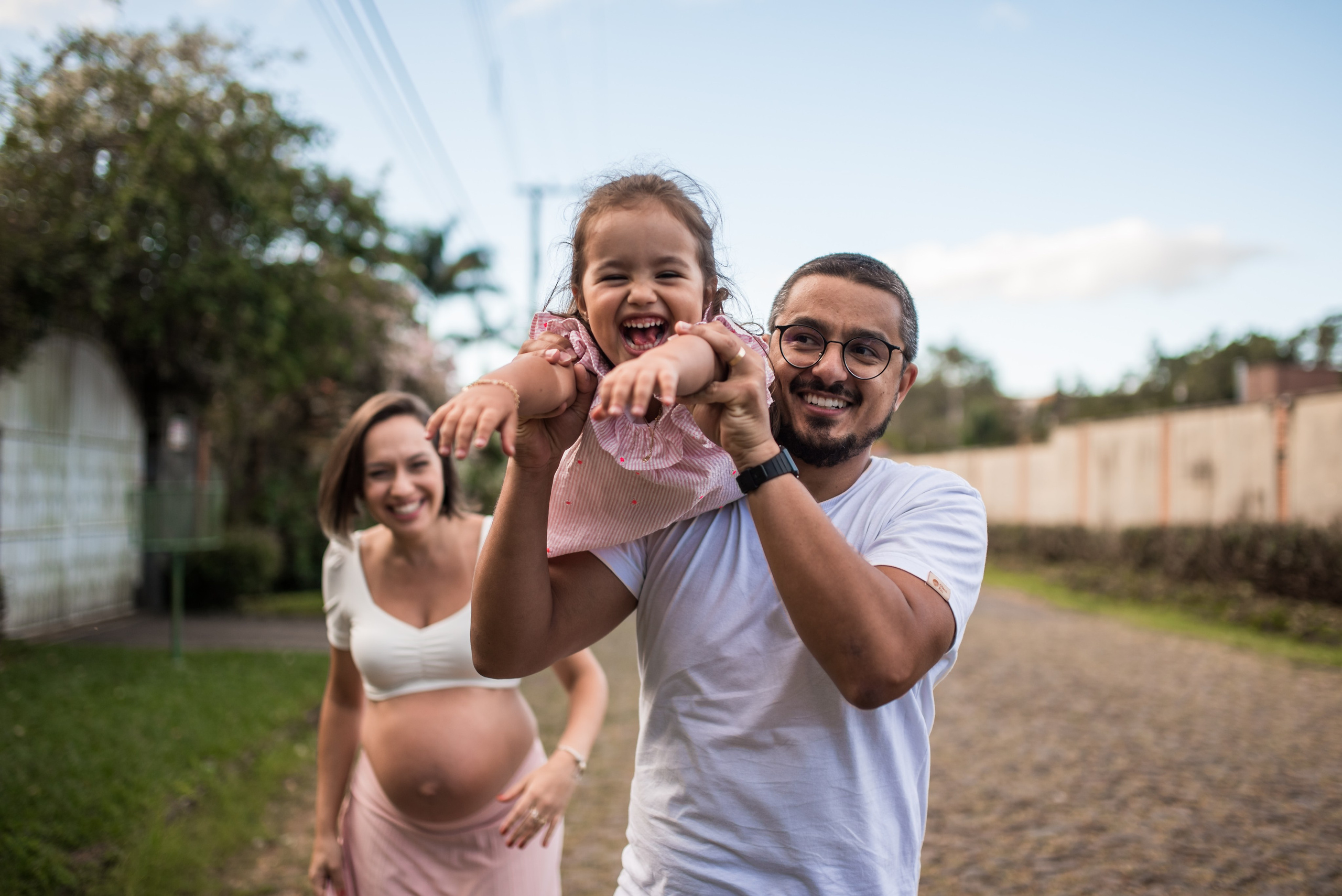 Ensaio gestante em família ao ar livre em Juiz de Fora, pai jogando a filha para o alto