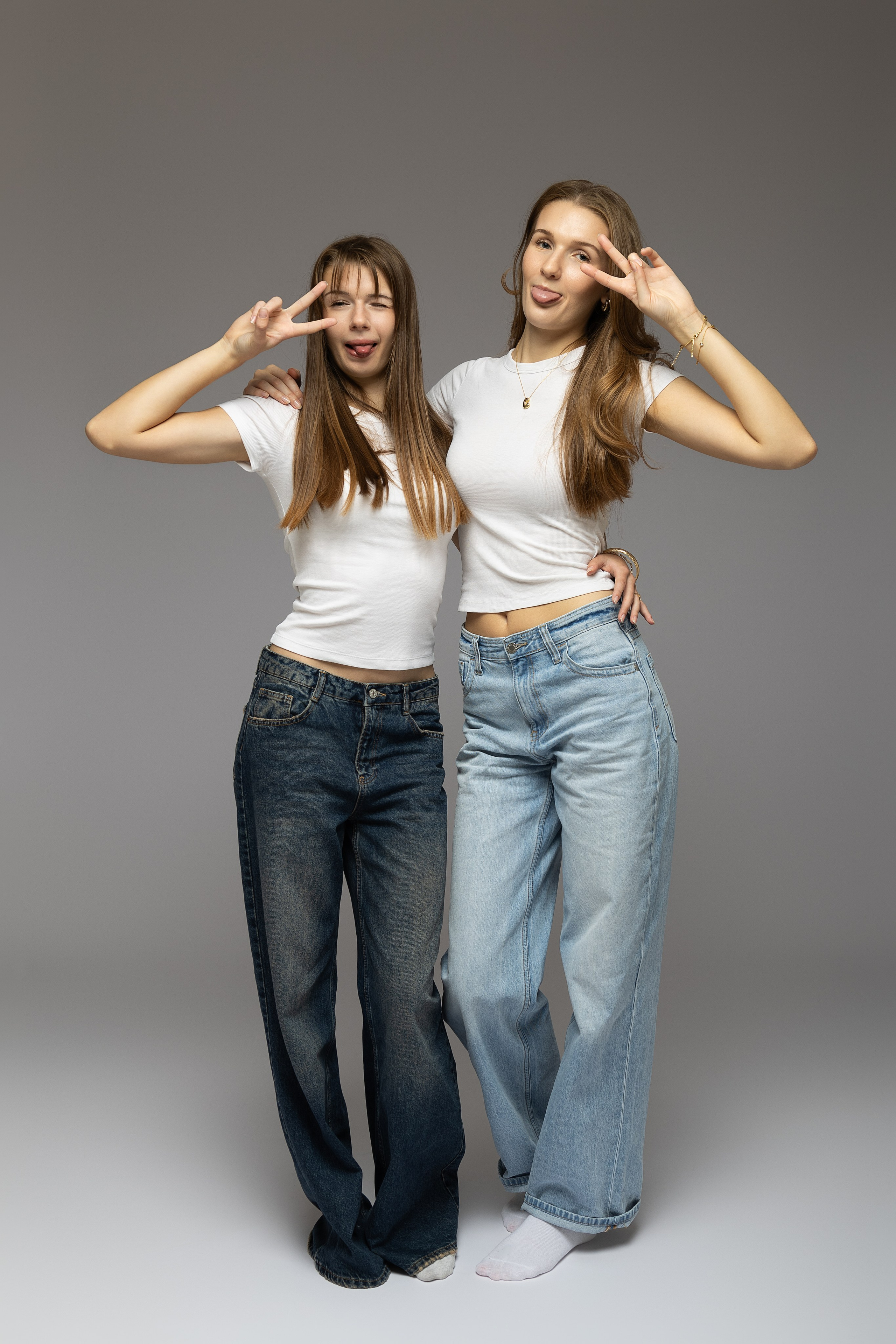  Studioaufnahme von zwei Schwestern mit zarter Umarmung und weichem Licht