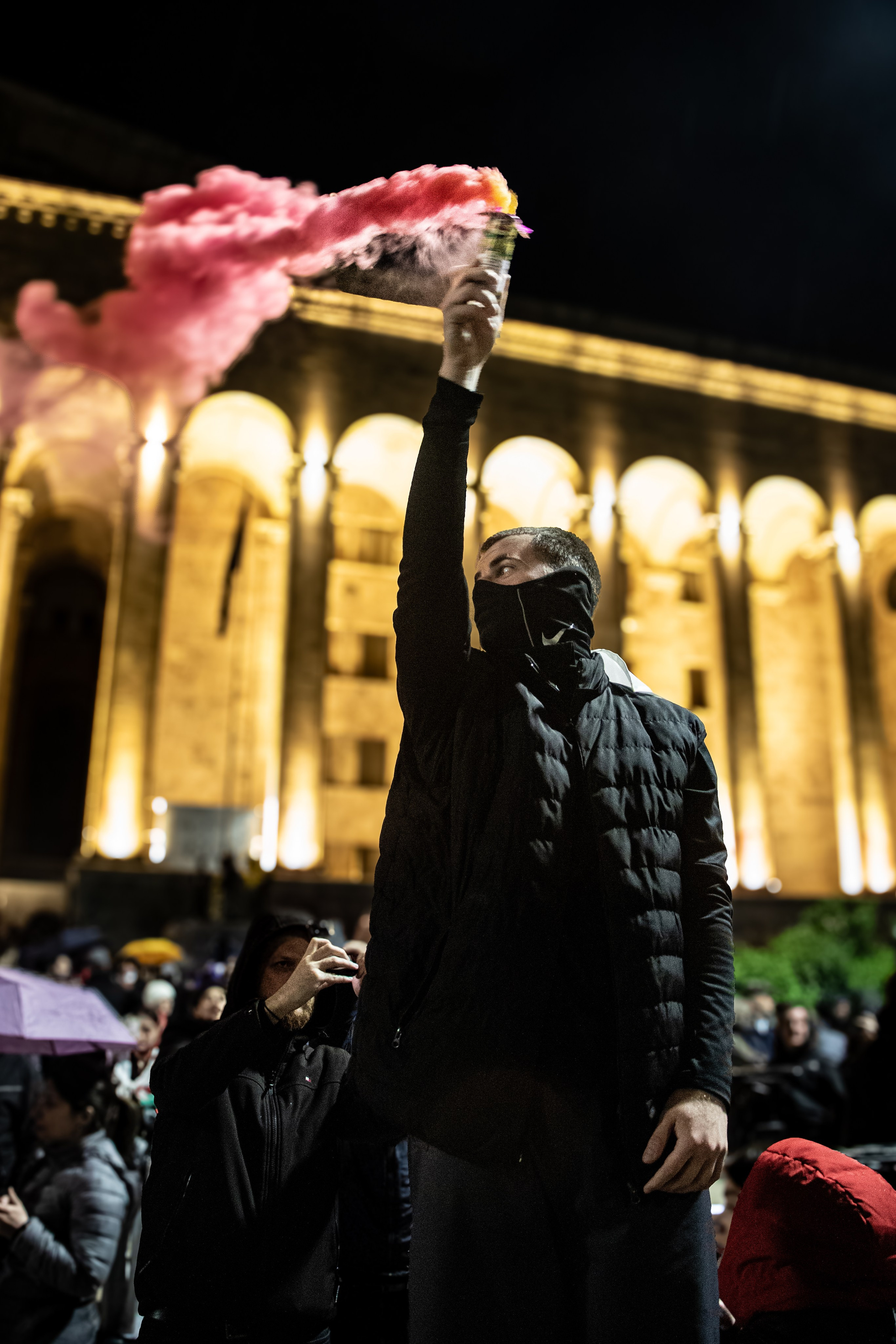 Un jeune de l’opposition au pouvoir, brandit un fumigène.