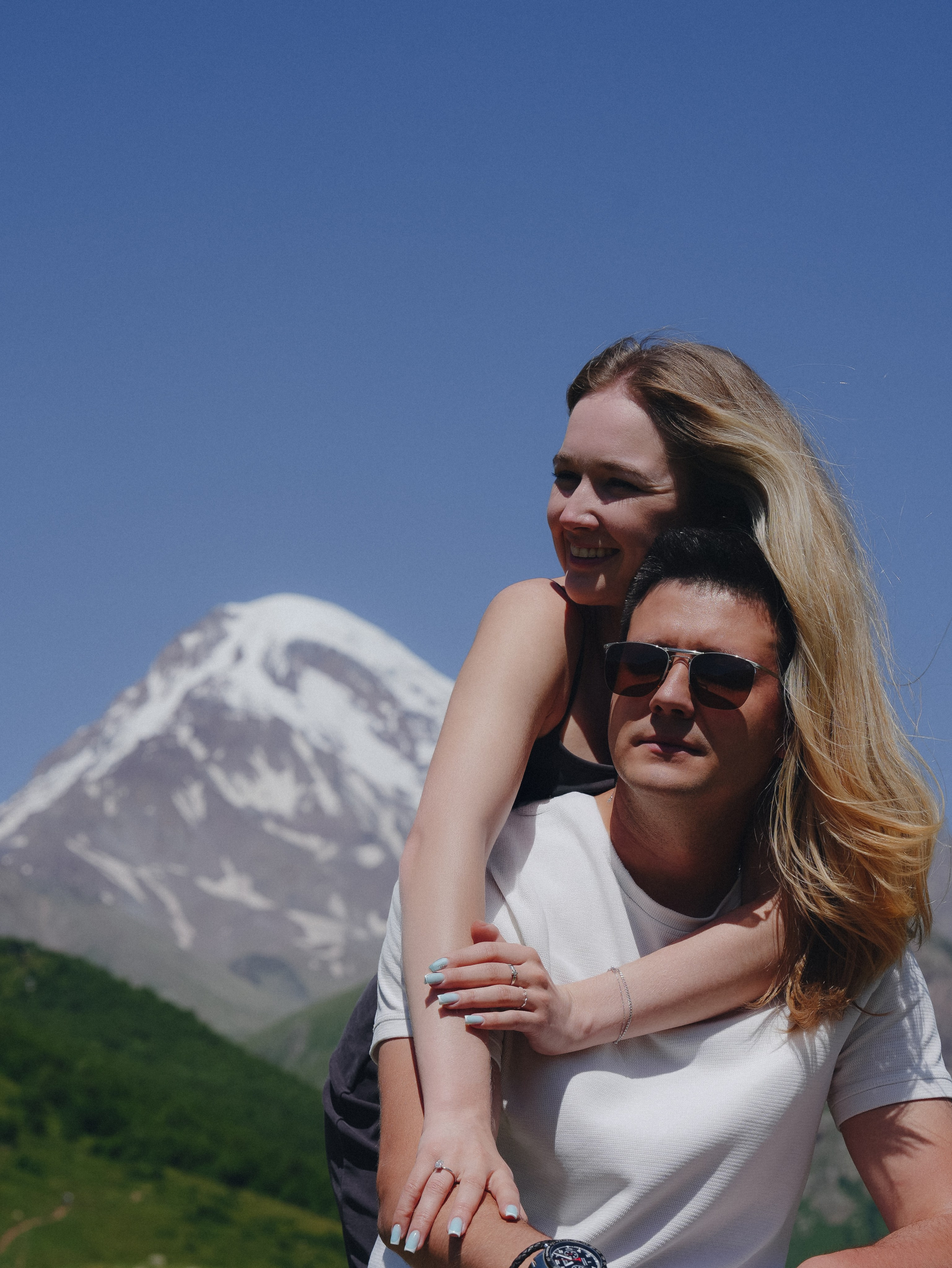 Couple on mountain viewpoint after engagement in Kazbegi