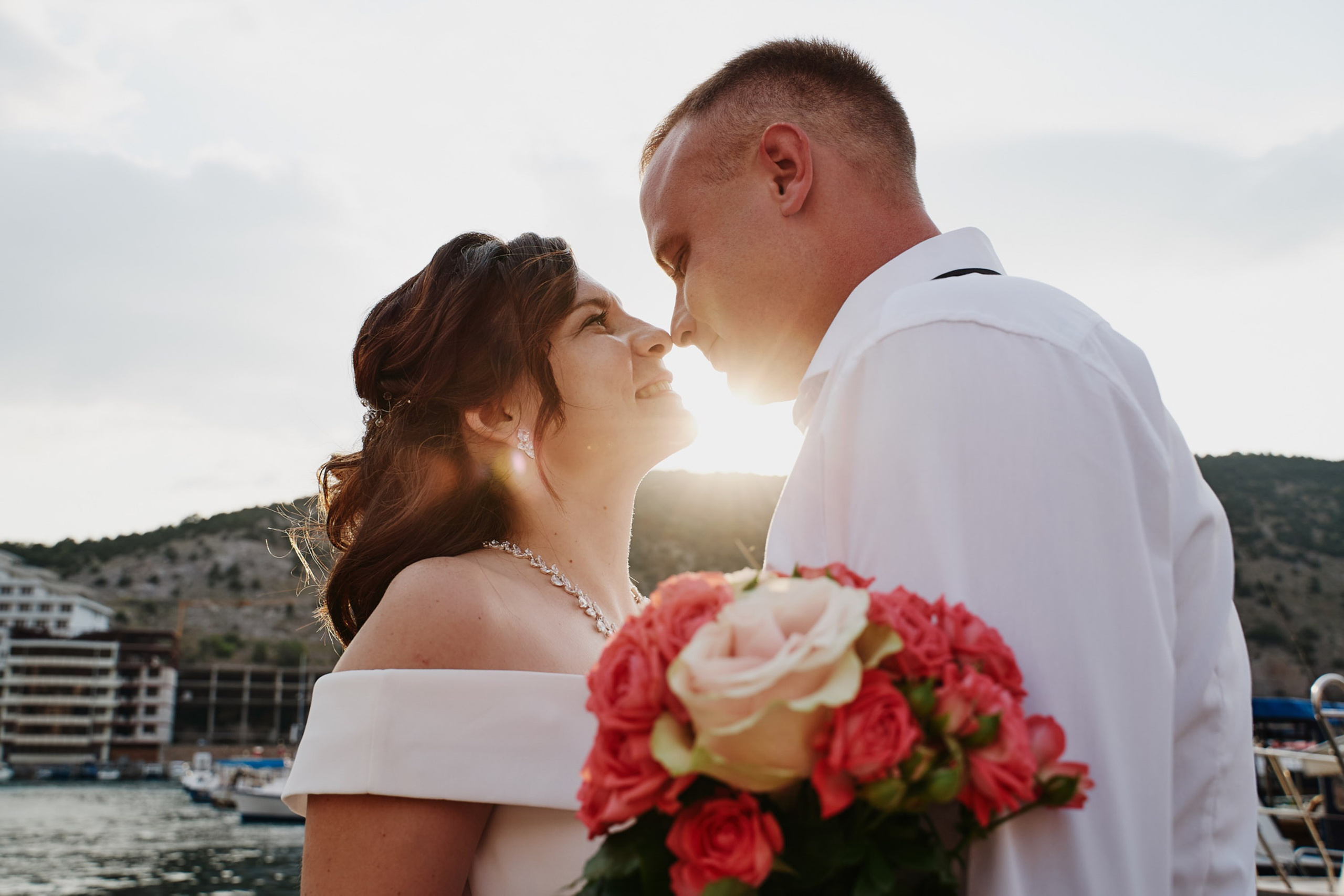 Bride and groom kissing with city background, romantic moment