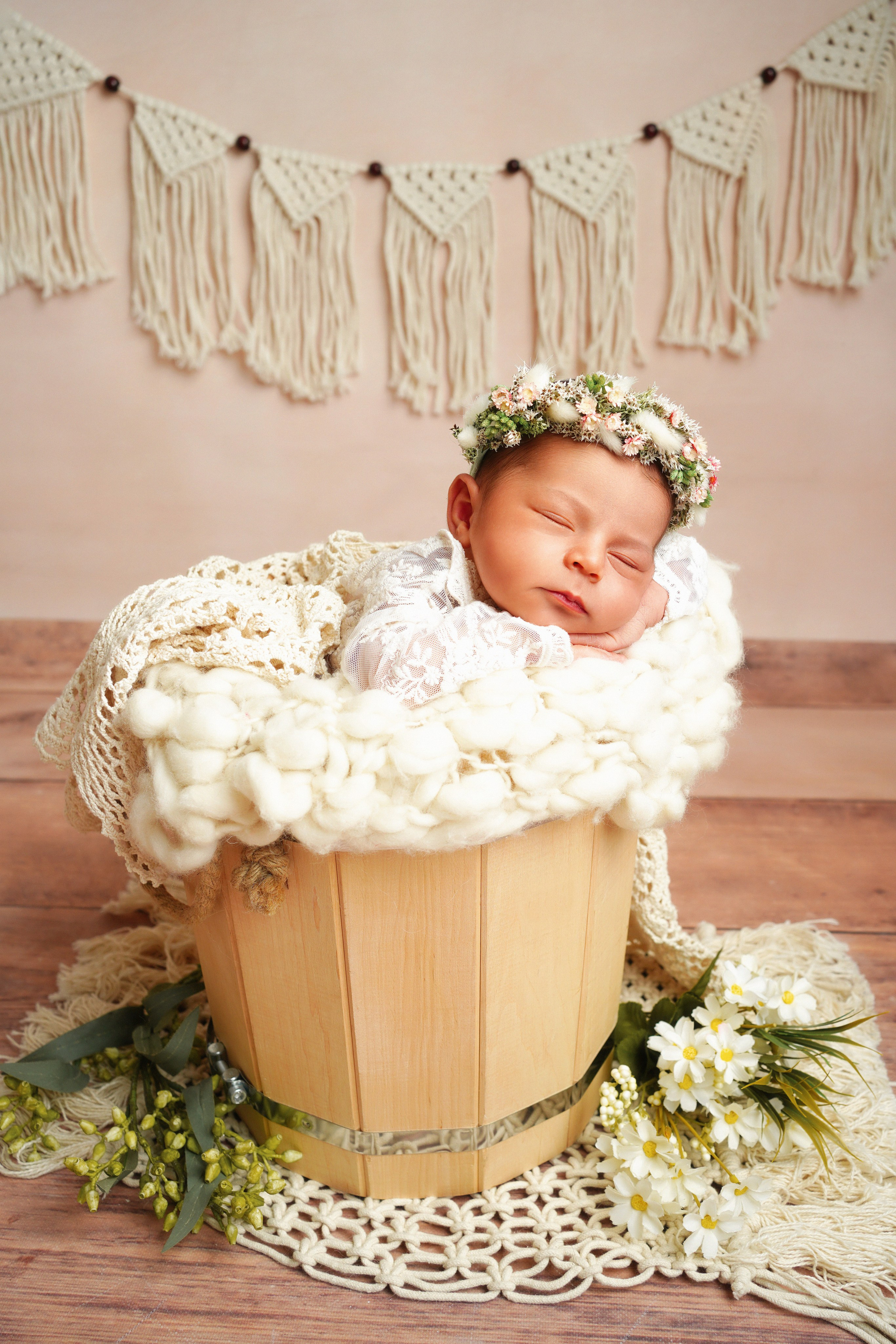 Baby liegt auf Bauch, Hände unter dem Kinn