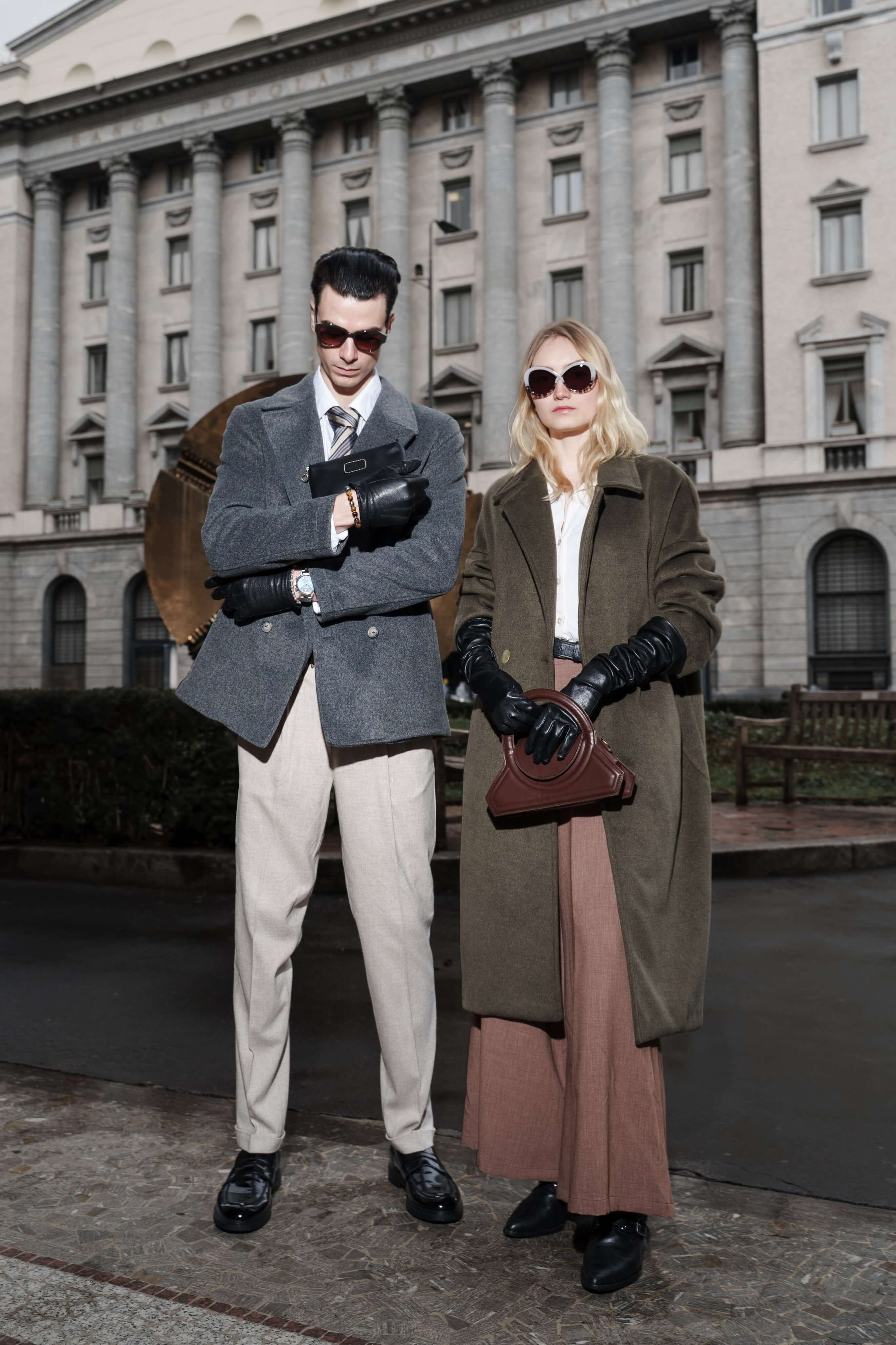 Man and woman posing in front of the Banca Popolare di Milano in elegant winter outfits