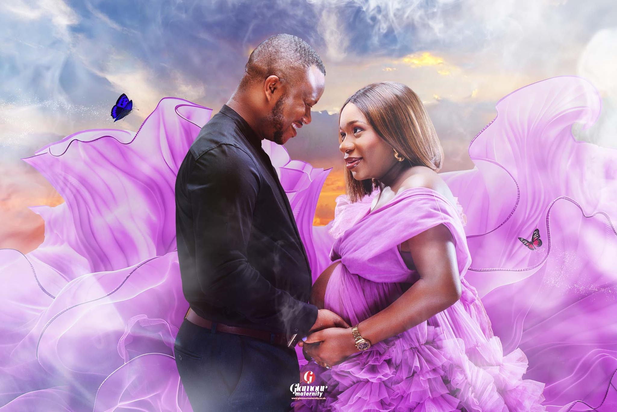 Romantic maternity portrait of an expectant couple surrounded by flowing purple fabric, soft clouds and butterfly details.