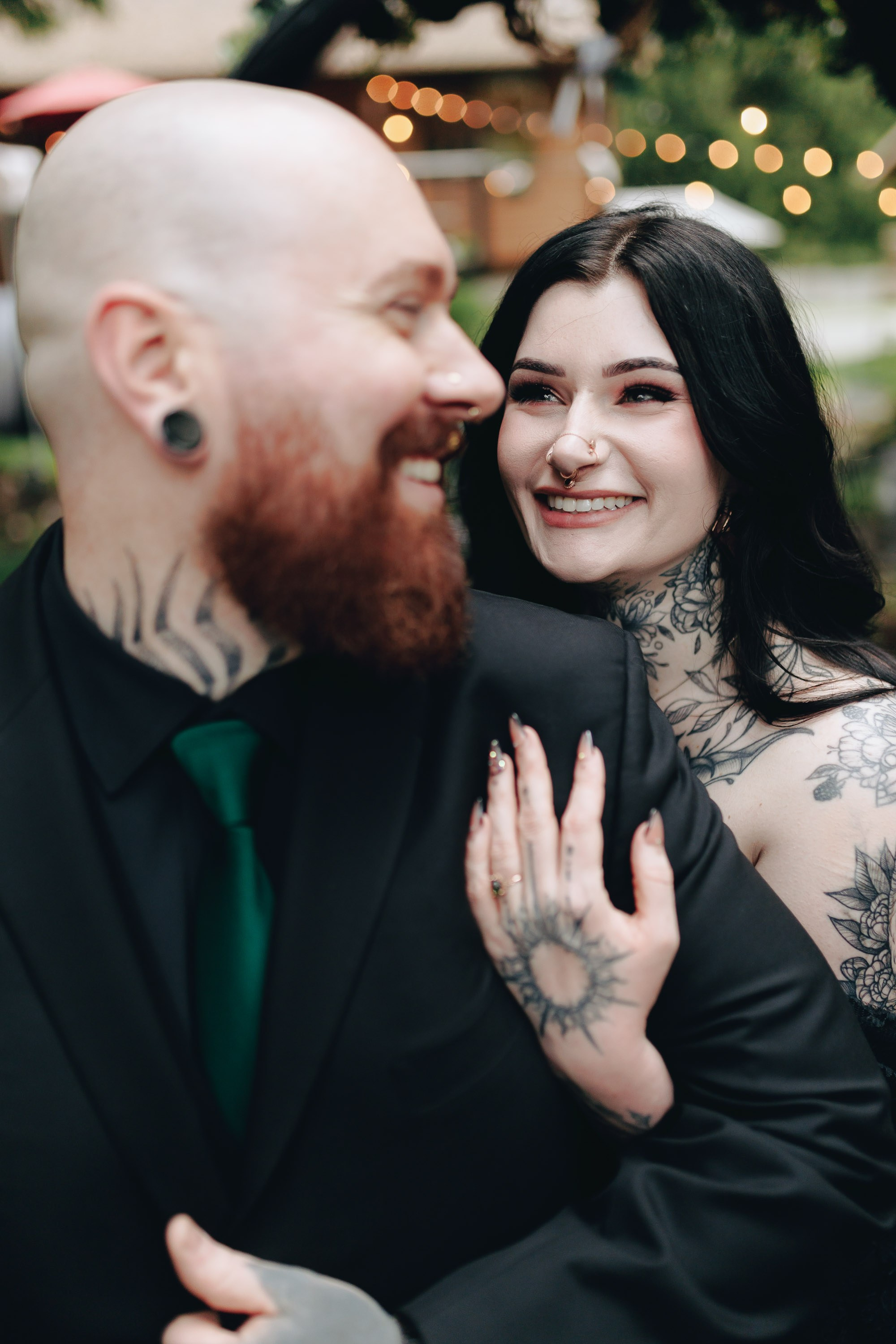 Tattooed couple smiling and embracing, alternative wedding style