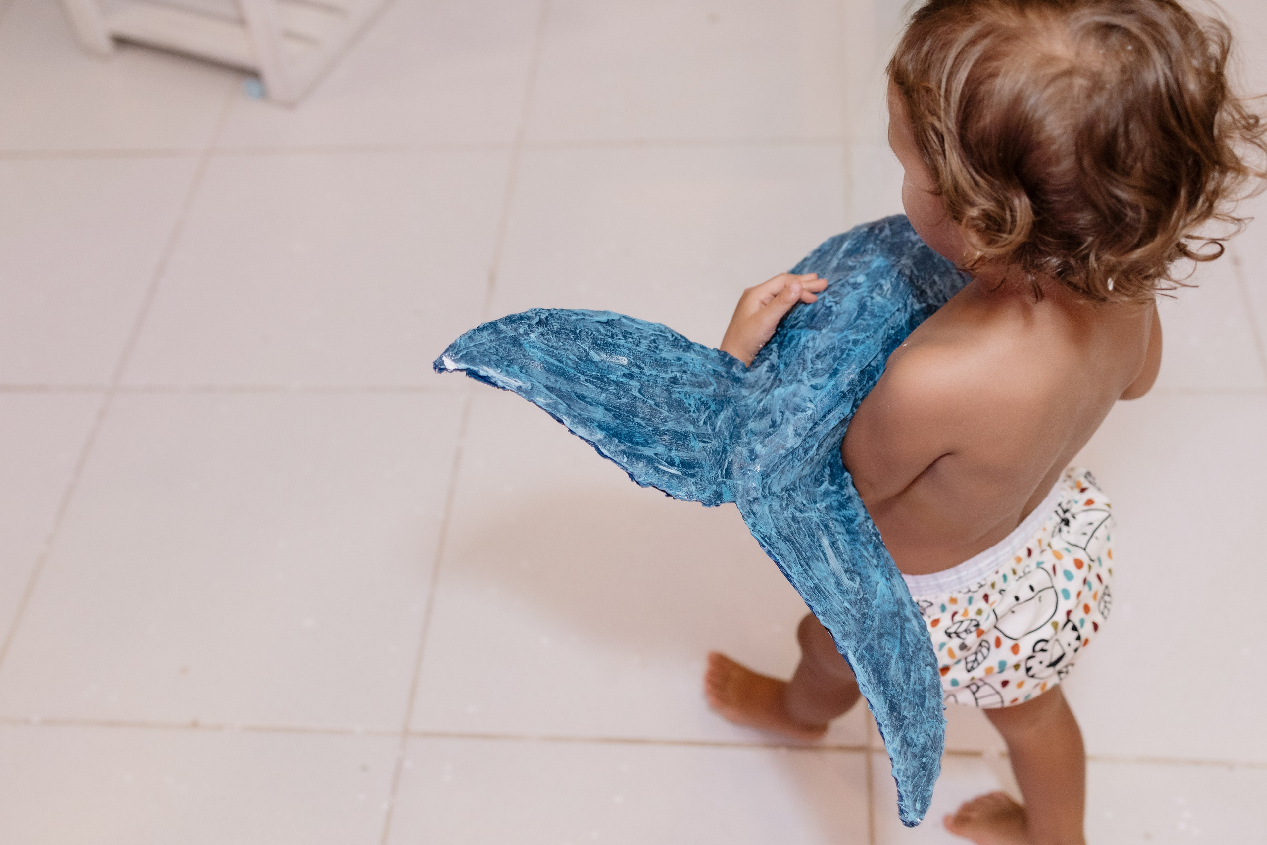 Fim de festa infantil com menina carregando parte da decoração
