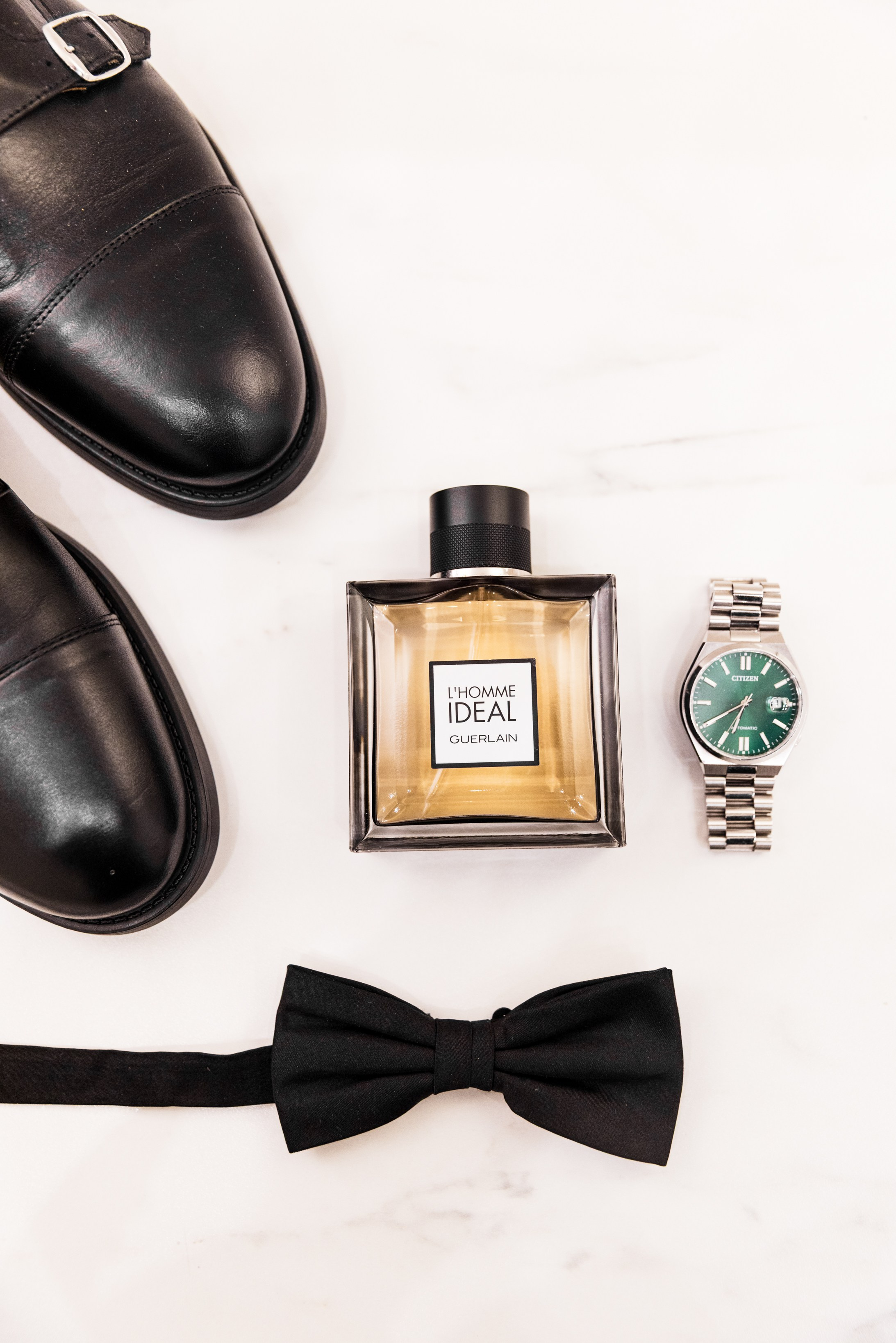 Hochzeitsdetails als Flatlay: Schuhe, Parfum und Fliege