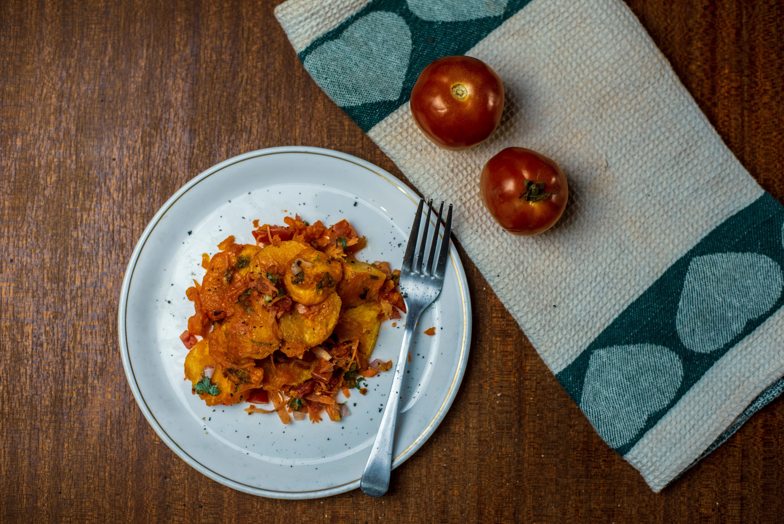 A plate of 'bhajias' ( deep fried potatoes) with tomatoes on the side- food photography styling