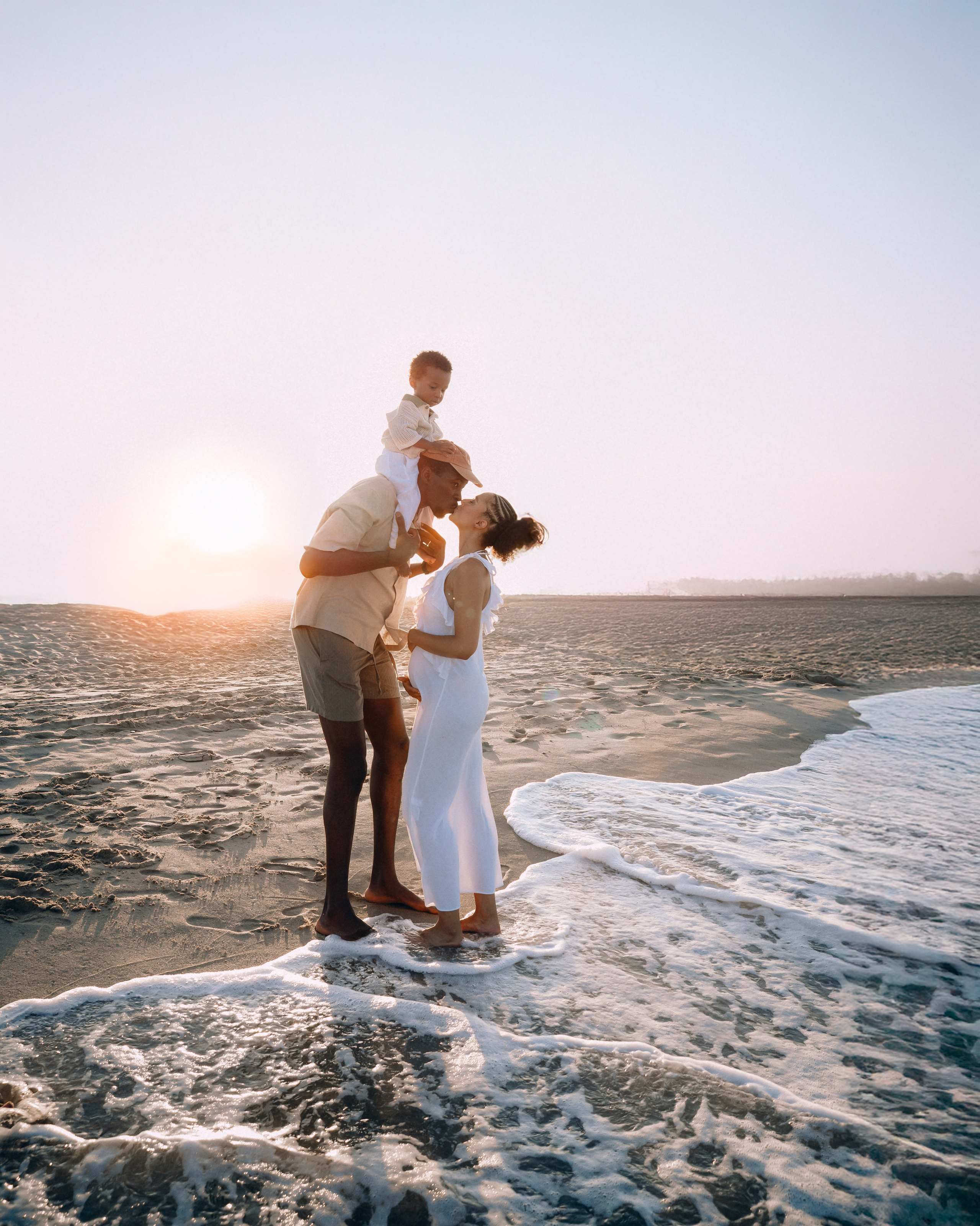 Familia feliz al borde del mar durante una sesión al atardecer en Jávea, España — ideal para quienes buscan fotografía familiar emocional y espontánea en Jávea y a lo largo de la costa mediterránea.