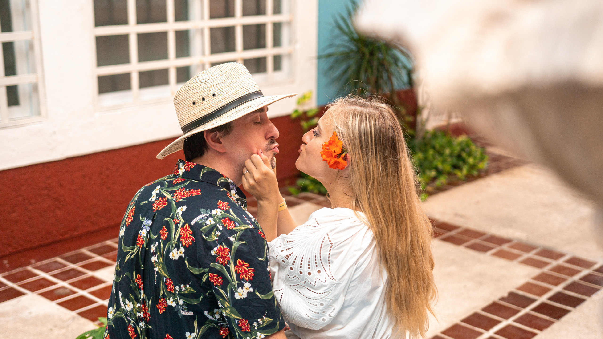 Emotive and colorful portrait of two lovers walking through a picturesque Cancún street with classic Mexican textures.