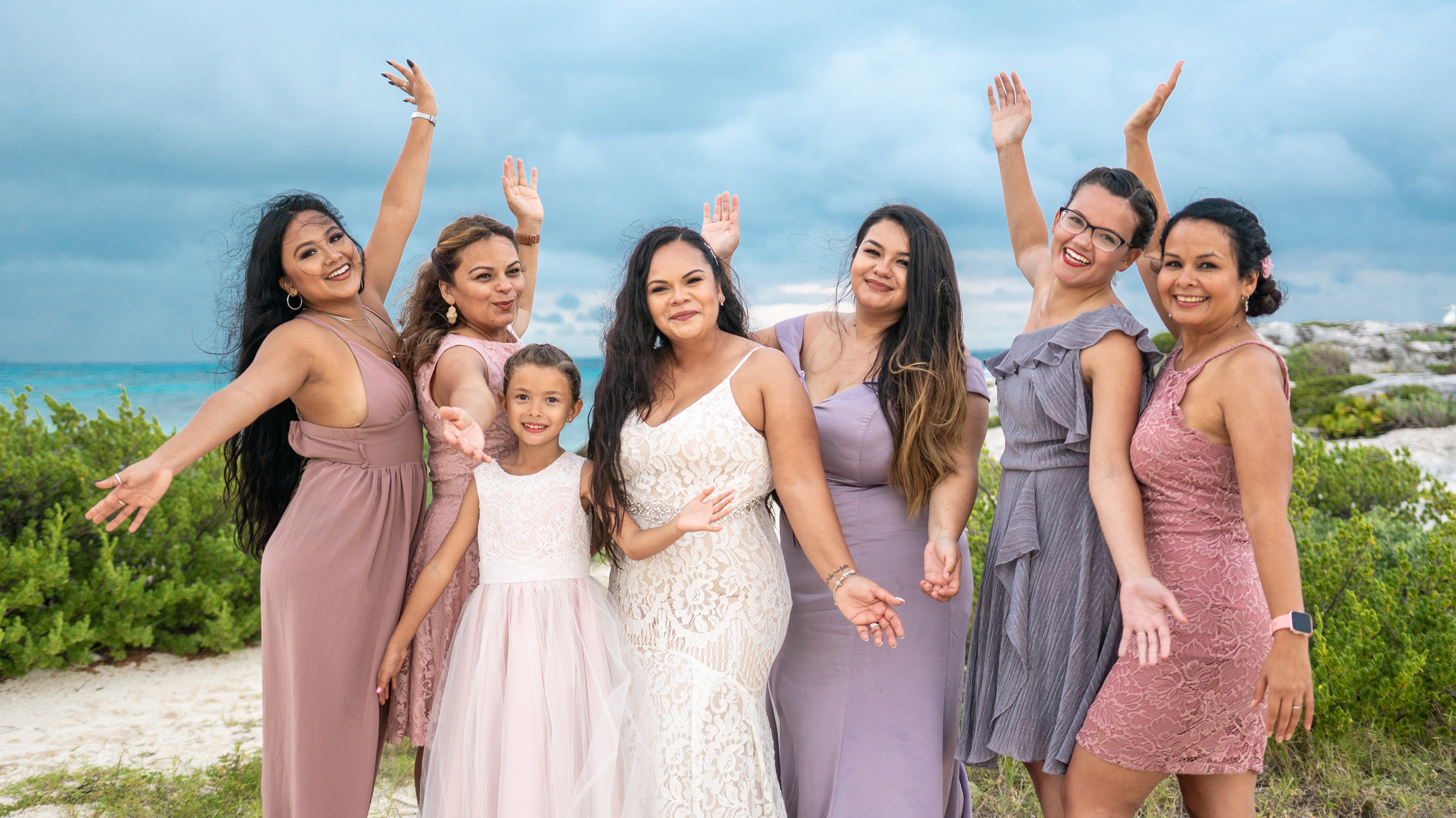 Group wedding photo on the beach with lighthouse in Cancun, Mexico
