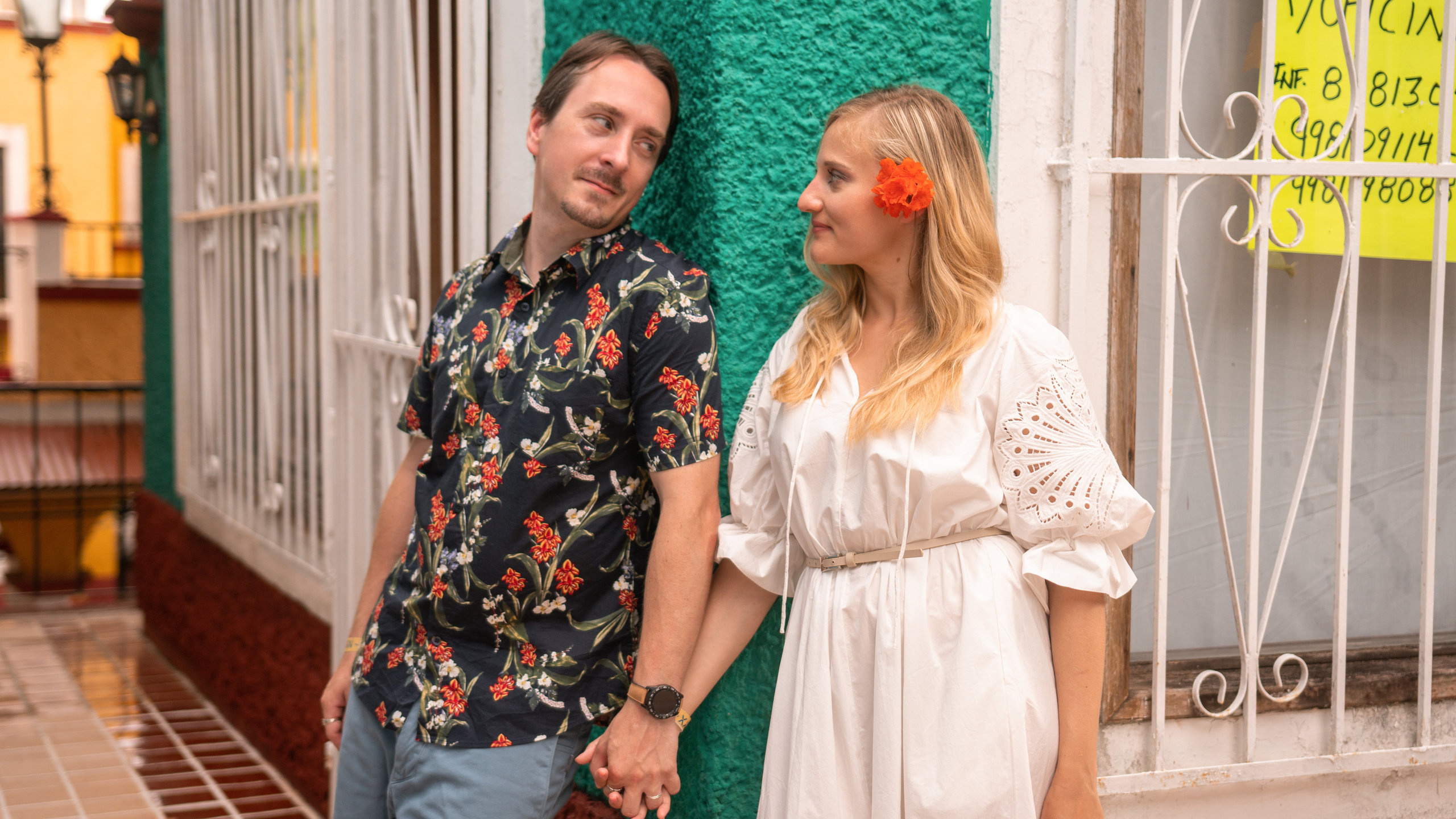 Downtown Cancún couple photography in front of a local colonial home, captured with warm tones and natural expressions.