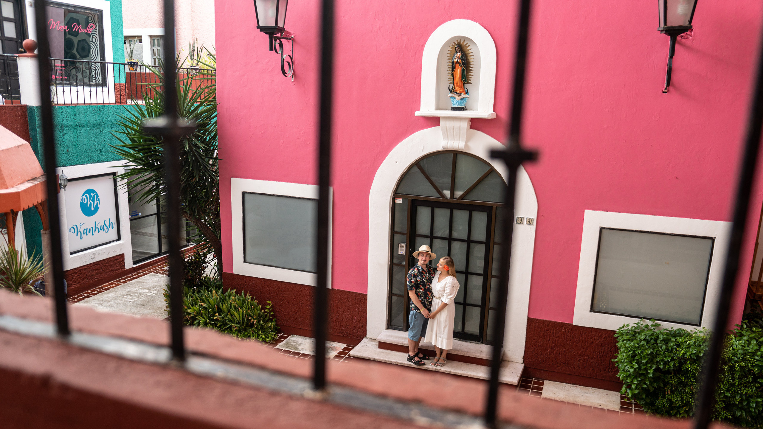 Natural light photo of a couple sitting on traditional tiled stairs surrounded by coral walls in Cancún, taken by a destination couple photographer