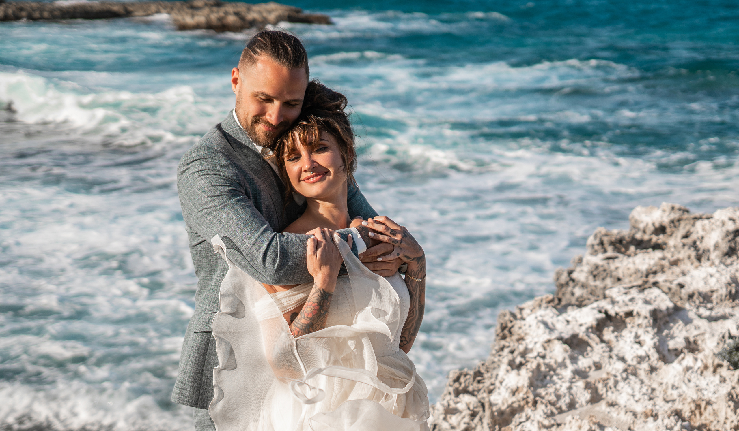 Windswept couple portrait on the rocks – destination wedding photographer
