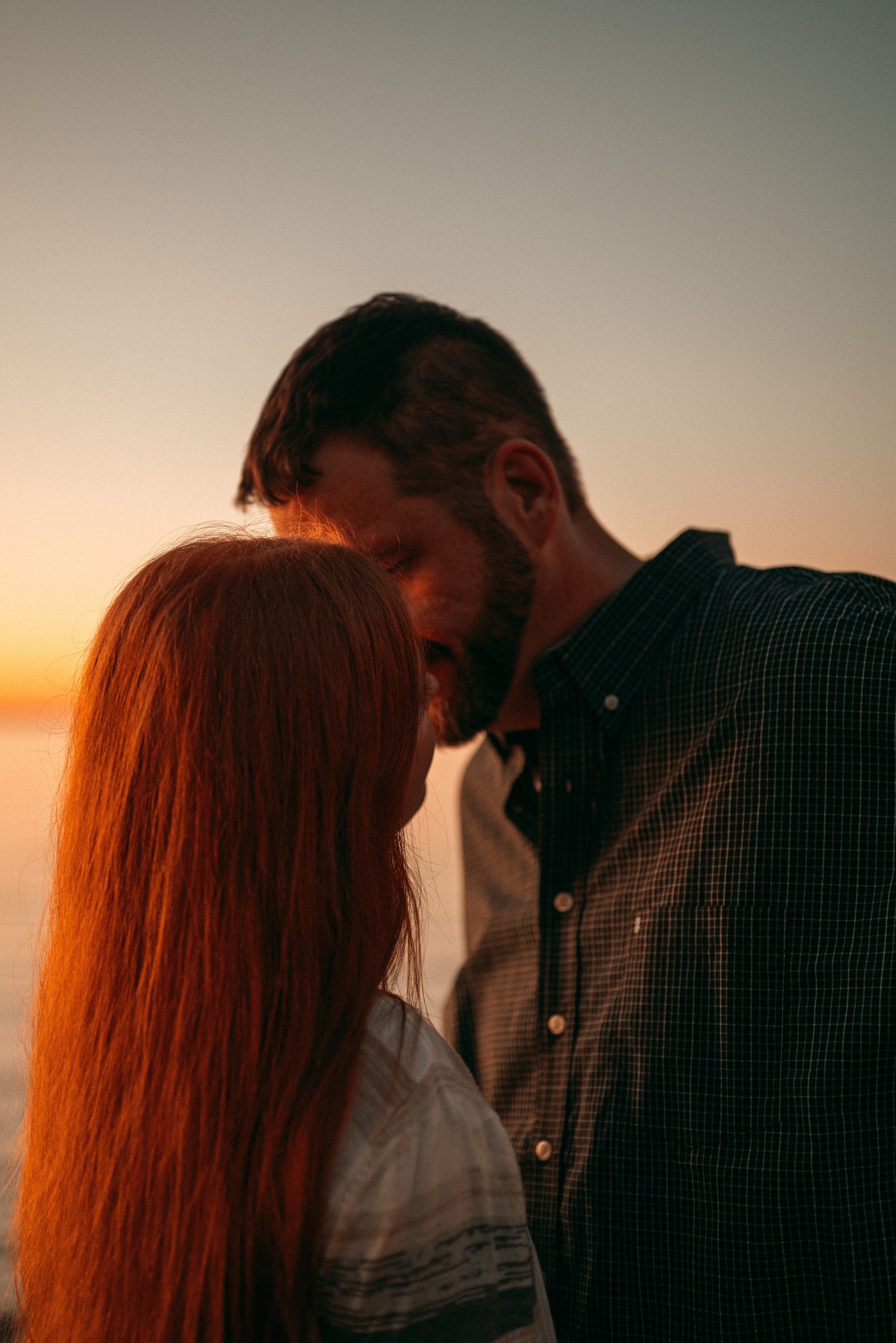 "Golden hour portrait of a couple against the warm hues of a Green Bay sunset, highlighting a romantic outdoor session.