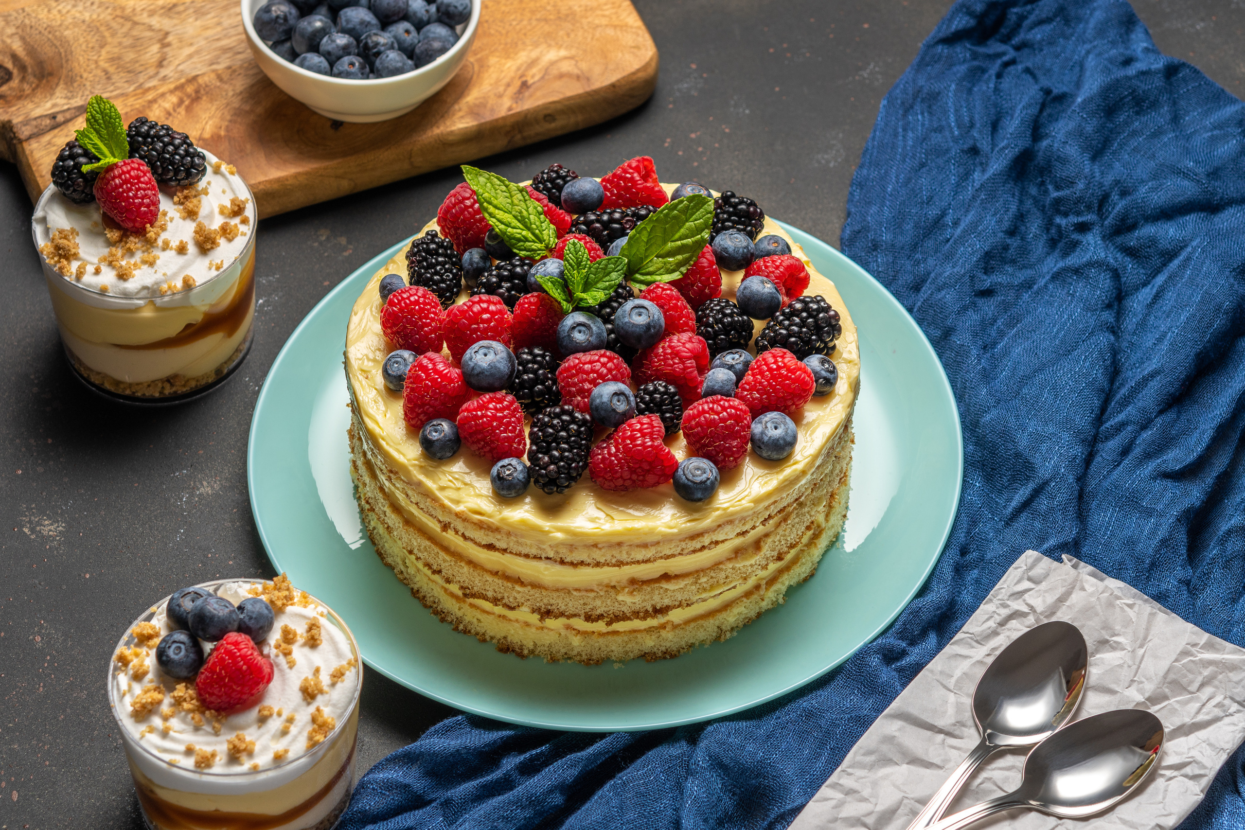 Homemade cake with fresh berries and sweet desserts on dark background. 