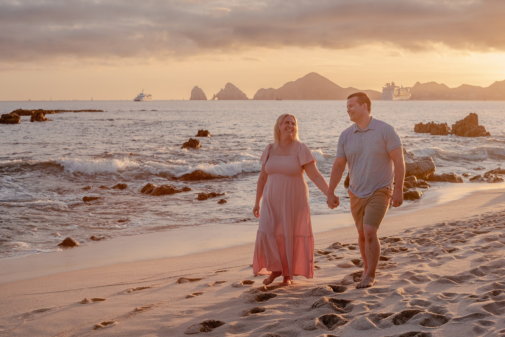 Family of four with baby and grandmother posing for beach portraits near El Arco at Playa Monumentos Los Cabos