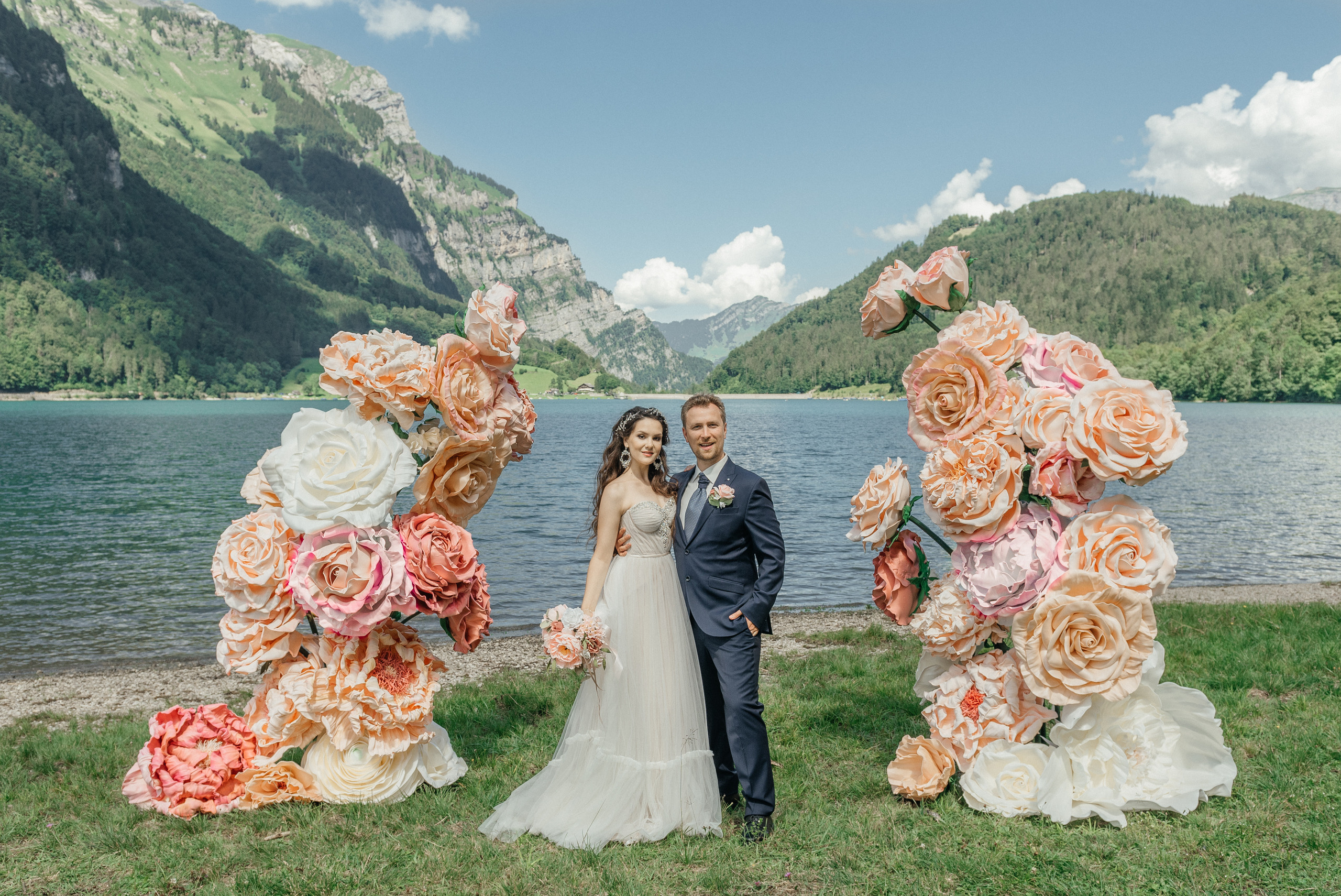 A happy wedding couple in flowers on the swiss lake in the mountains. Switzerland. The Alps