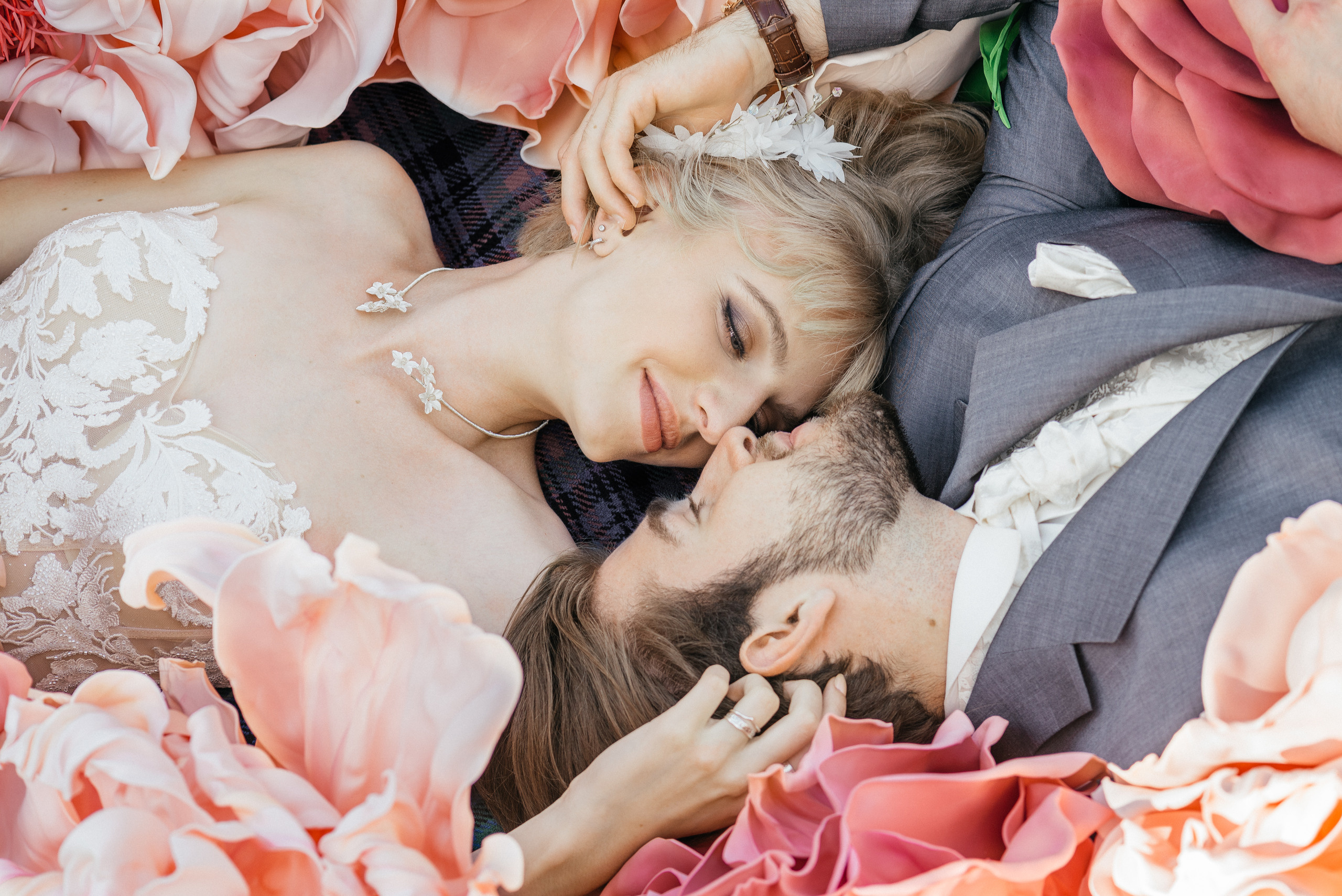 A romantic wedding couple in big flowers. Bride and fiance is looking to each other