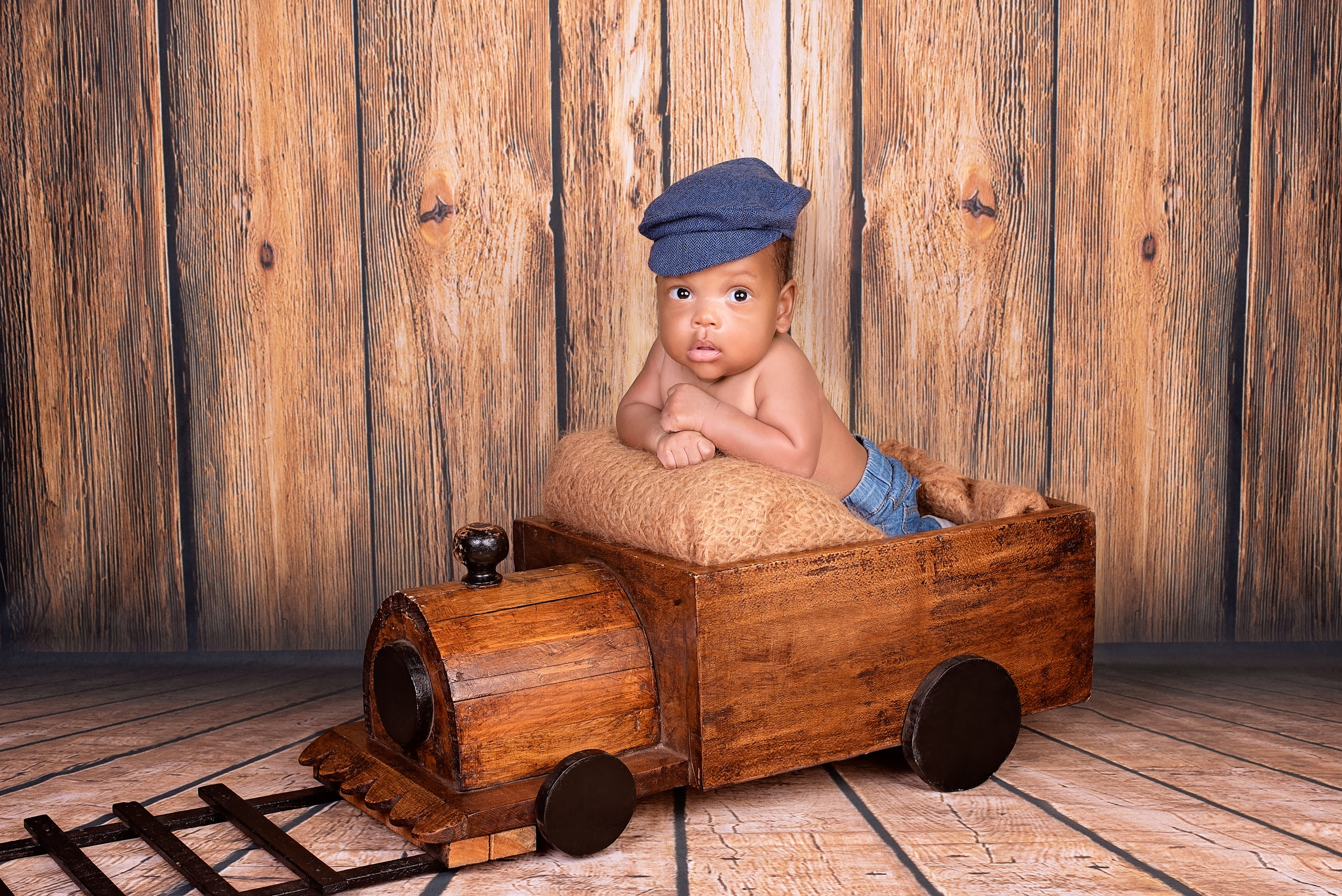 Black african baby boy in the wooden toy train photo shoot Nairobi Kenya