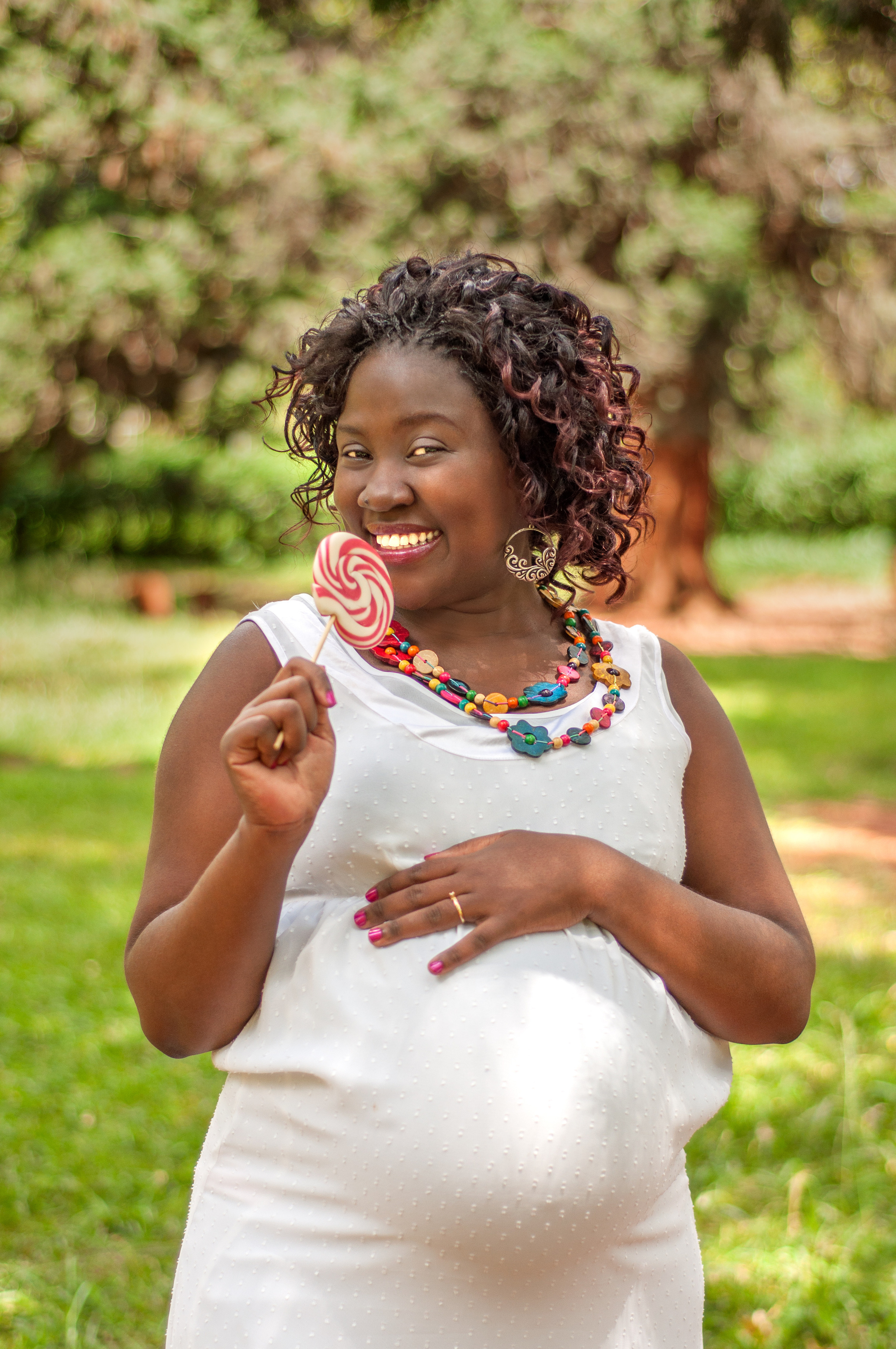 Beautiful African pregnant lady with loli pop in white dress Mombasa Kenya