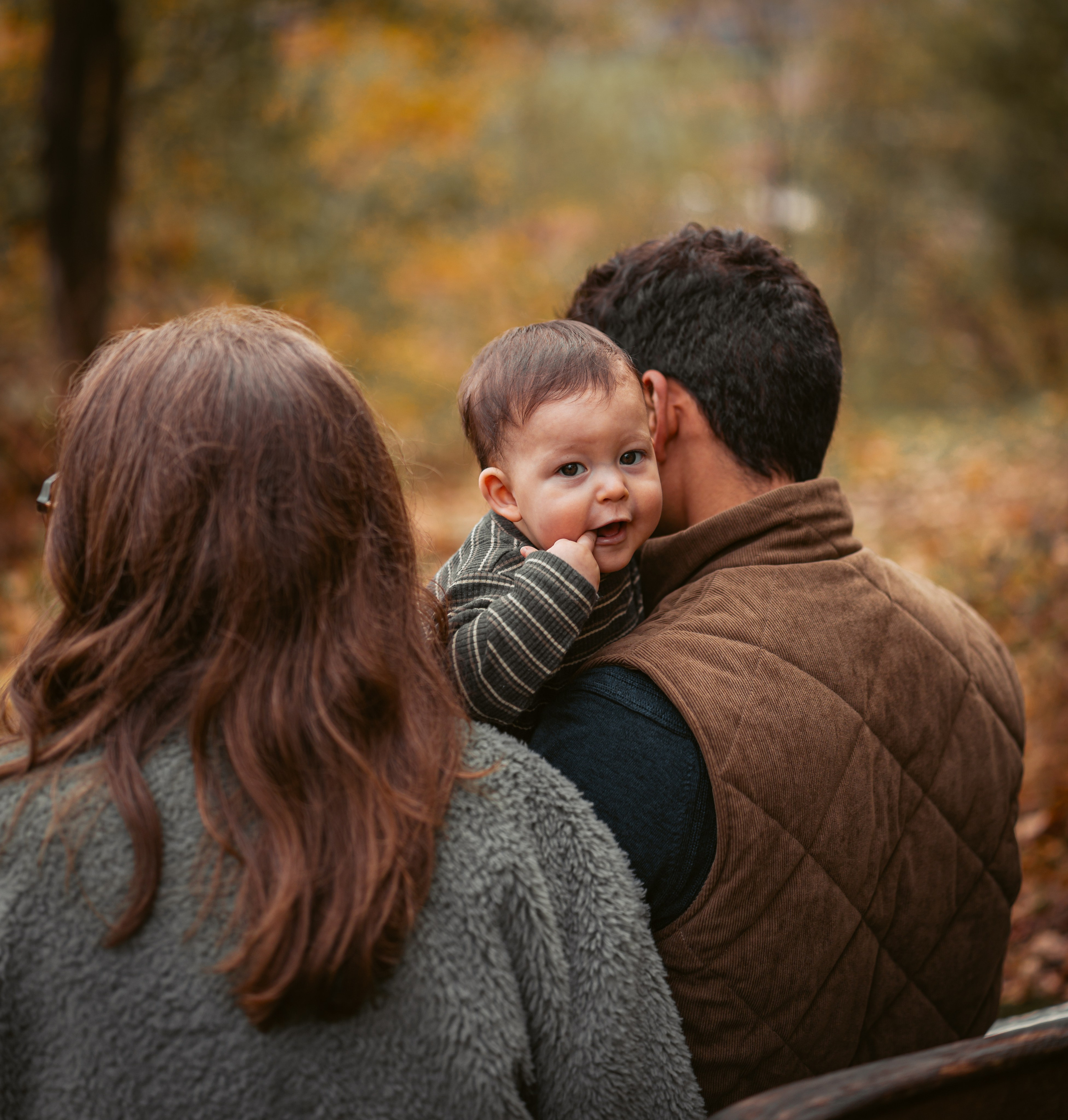 Papa tilt zoon op tussen oranje herfstbladeren - Kapture Fotografie
