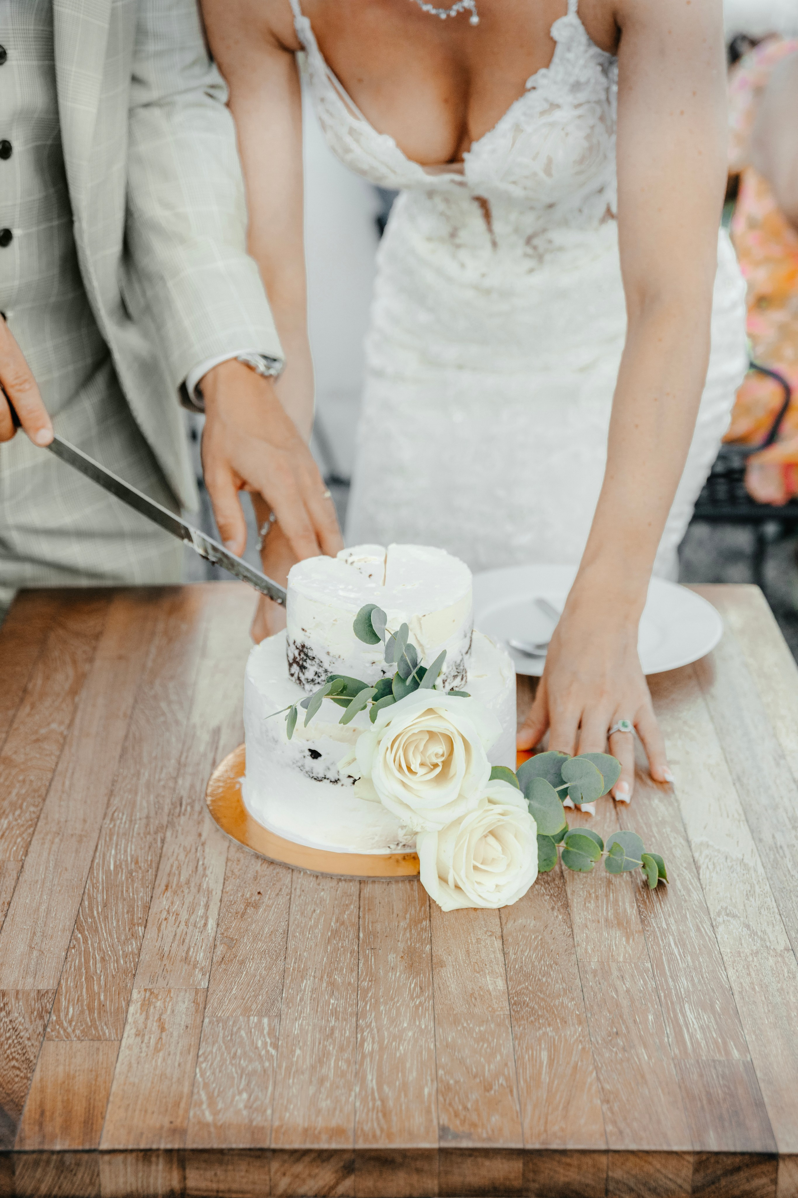 A Groom and a bride are cutting Wedding cake at a rustic bar in Lindos, Greece.
